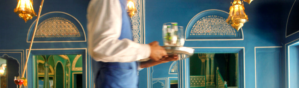 cropped image of a waiter carrying drinks on a tray