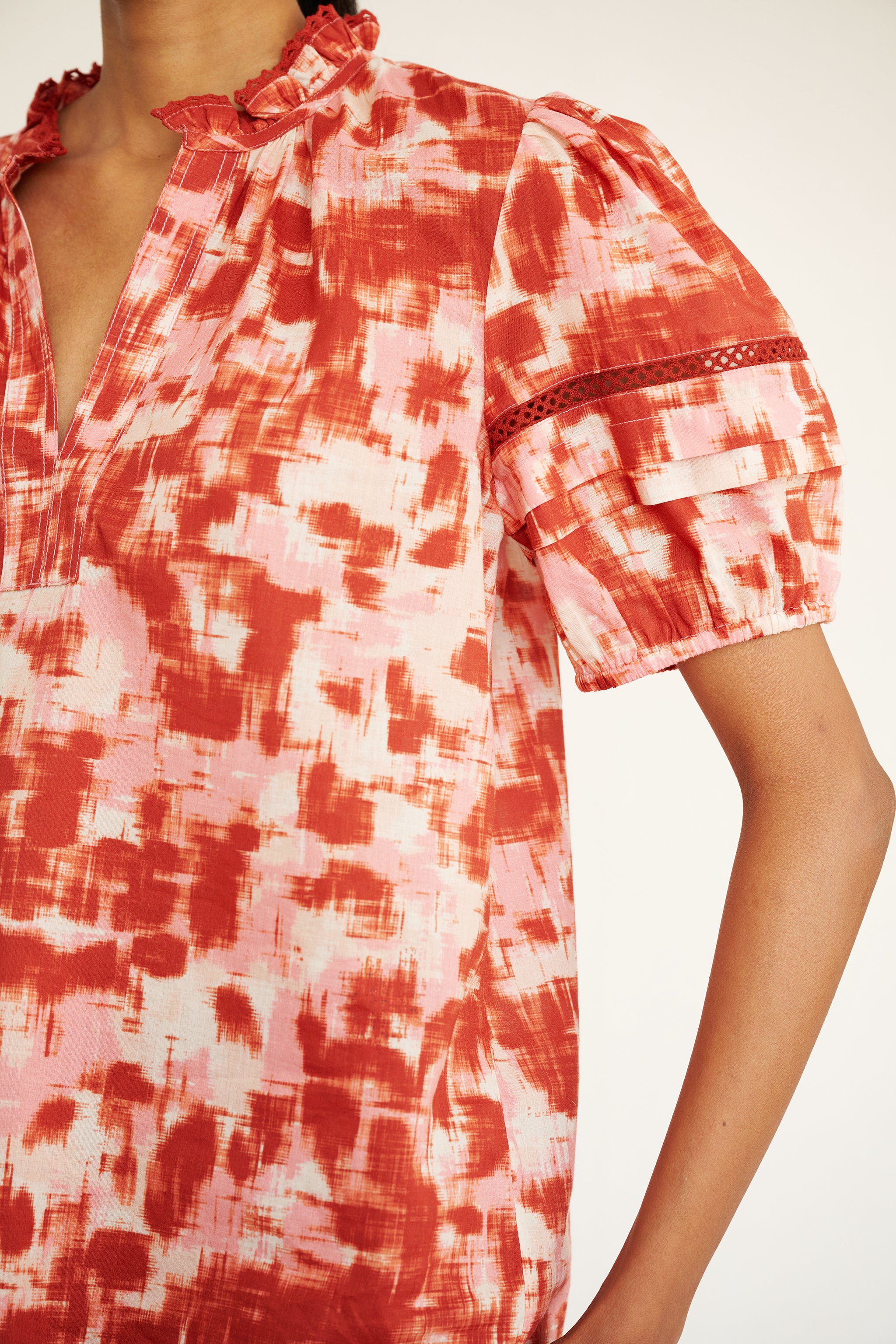 Close up of a Brontë Top Amur Honey showing a sleeve and neckline detail with lace.