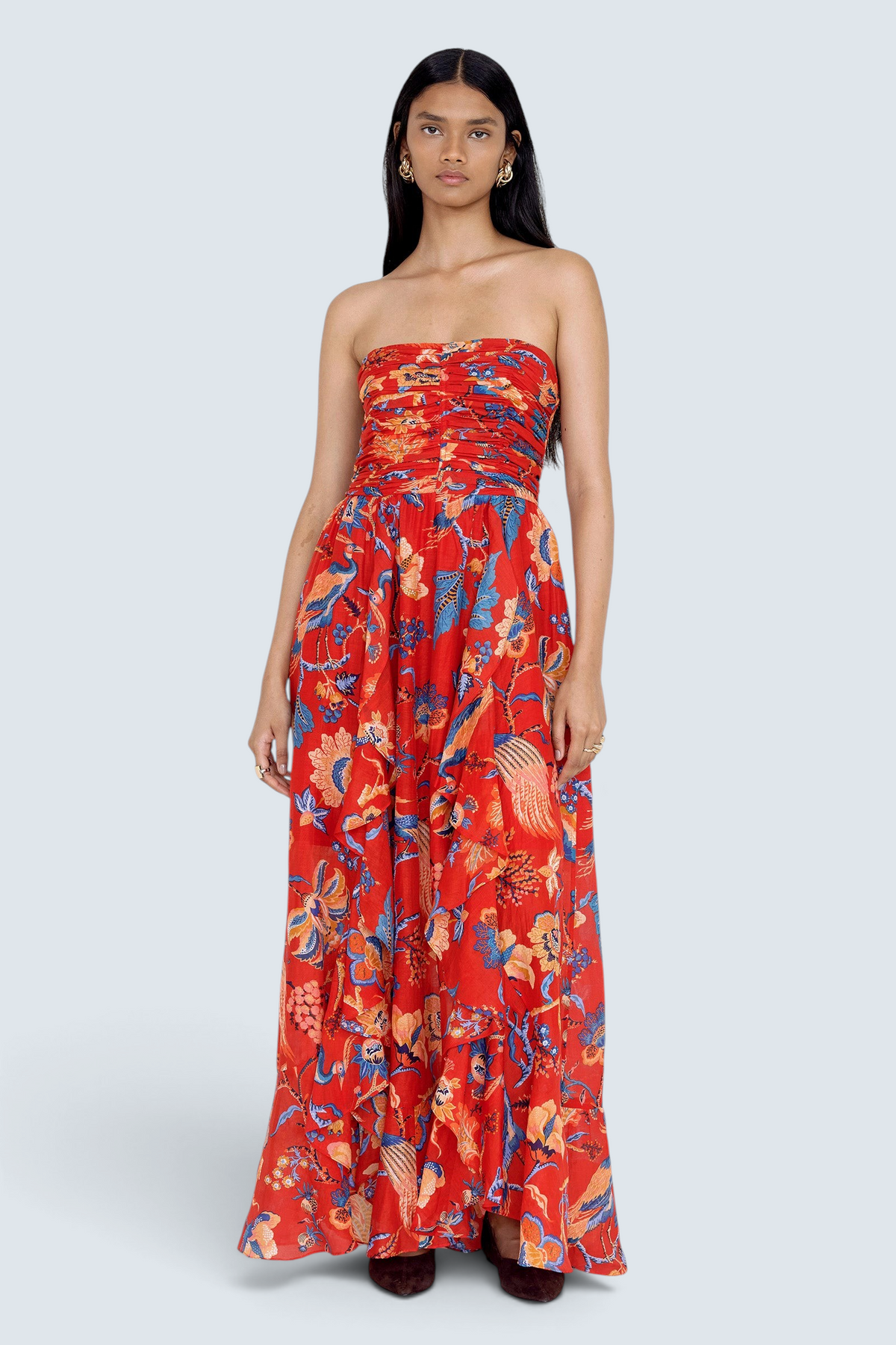 Front view of model standing. She is wearing the Bella dress in Chintz print. It features a full-length cascading skirt, subtle frill detail, ruched bodice, and smocked back.