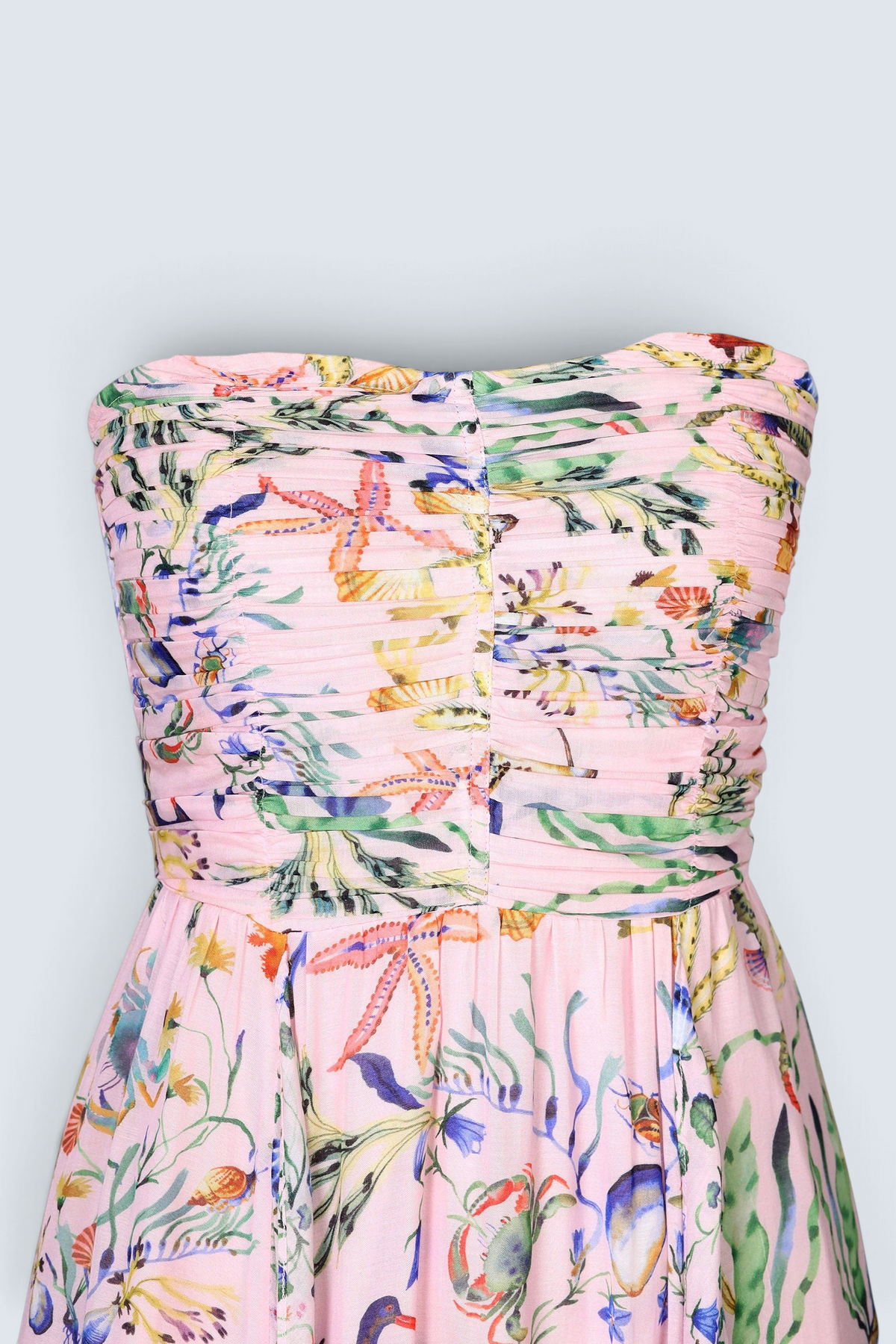 Banjanan Bella dress in pink viscose voile with Tidepool print featuring starfish, shells, and ruched bodice detail.