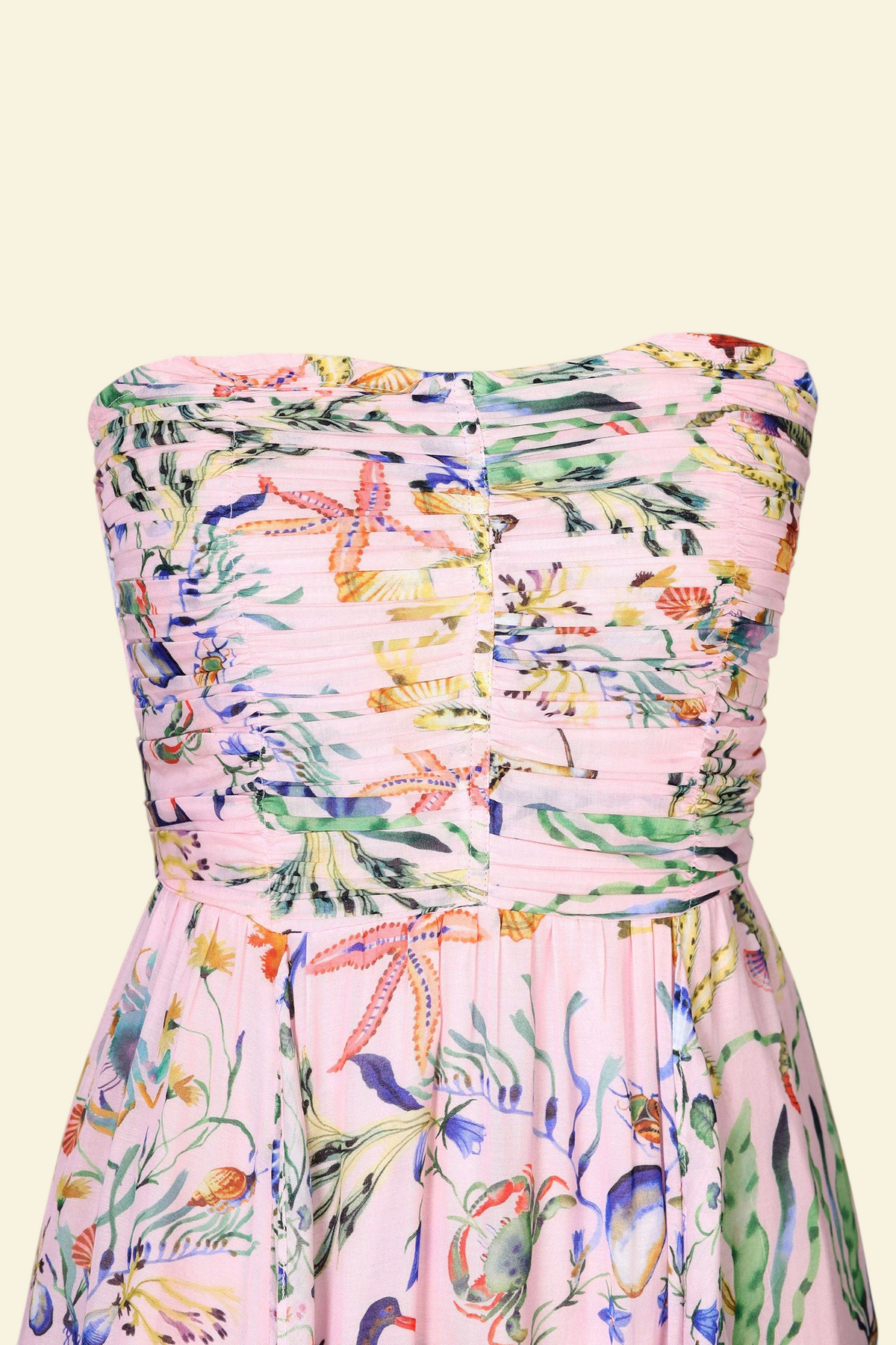Banjanan Bella dress in pink viscose voile with Tidepool print featuring starfish, shells, and ruched bodice detail.