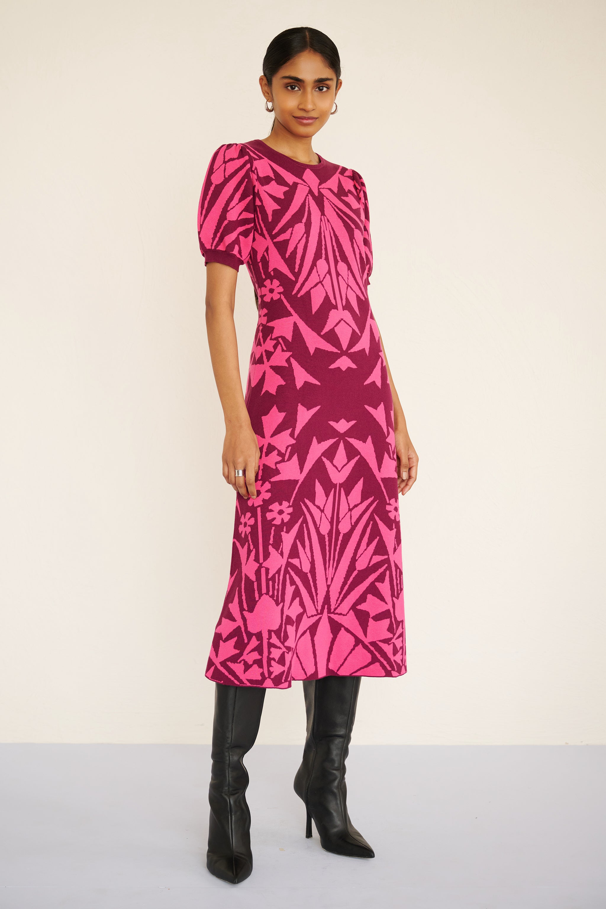 Front view of woman wearing a sleeveless jacquard midi dress with a fitted silhouette and hand-crocheted trim, featuring a textured, embroidery-inspired print.