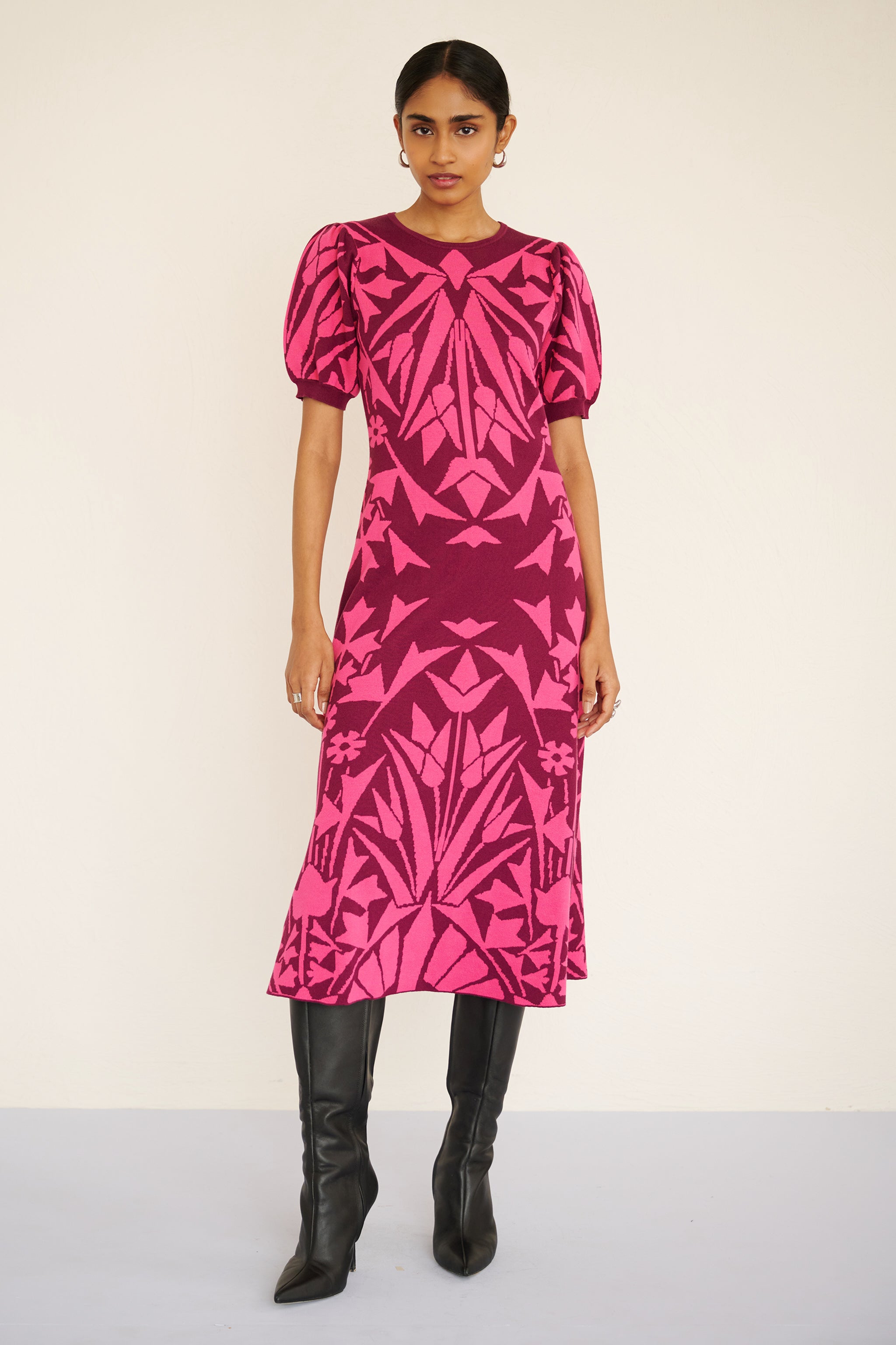Front view of woman wearing a sleeveless jacquard midi dress with a fitted silhouette and hand-crocheted trim, featuring a textured, embroidery-inspired print.