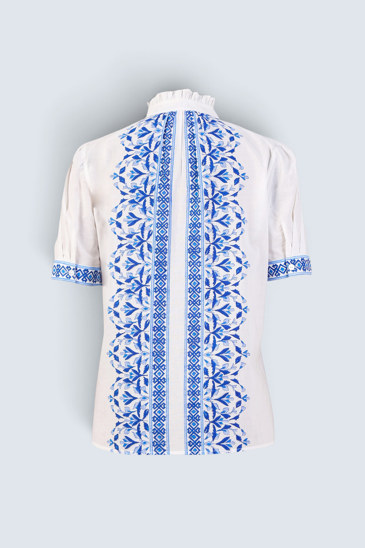 Back view the Christina button-up shirt with geometric floral block print, frilled collar, gathered neckline, and puff sleeves.