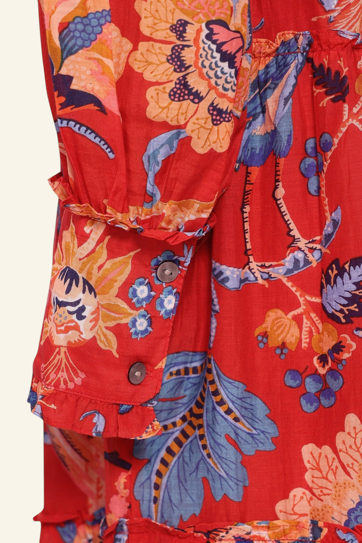 Banjanan Emira dress sleeve in carmine red cotton silk with floral chintz print, ruffles, and fabric-covered buttons.