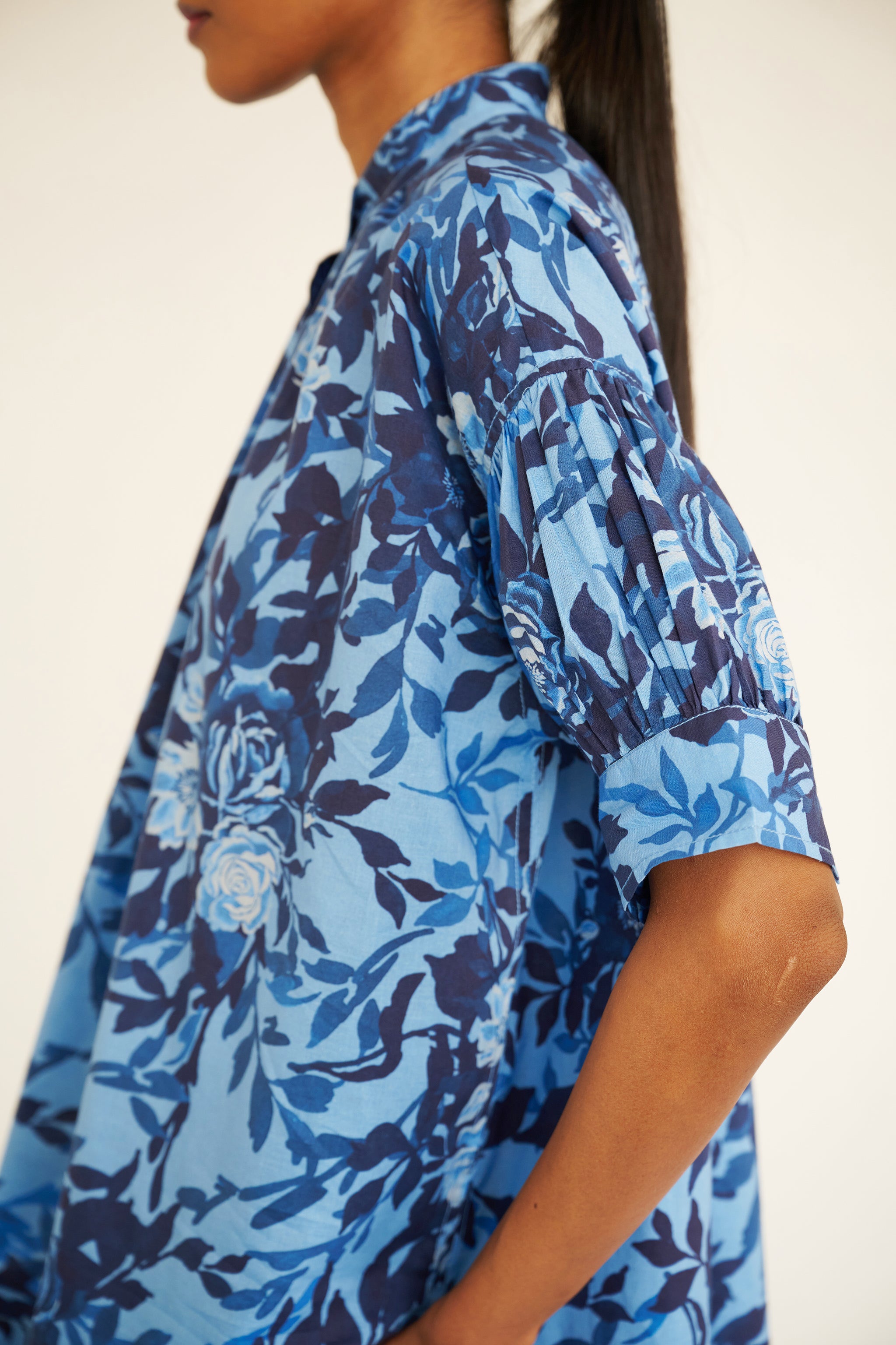 Close up of sleeve detail of woman wearing a relaxed floral button-down shirt.
