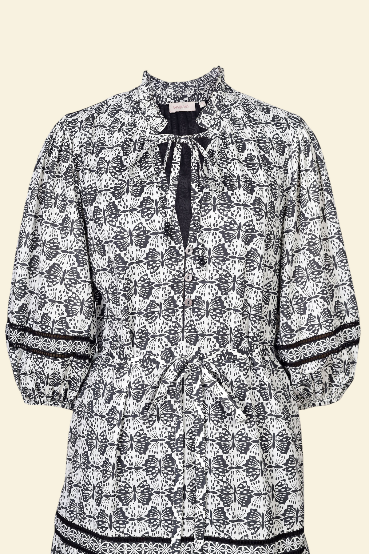 Banjanan Liza dress in black and white butterfly print cotton voile with ruffle neck, tie detail, and lace insets.