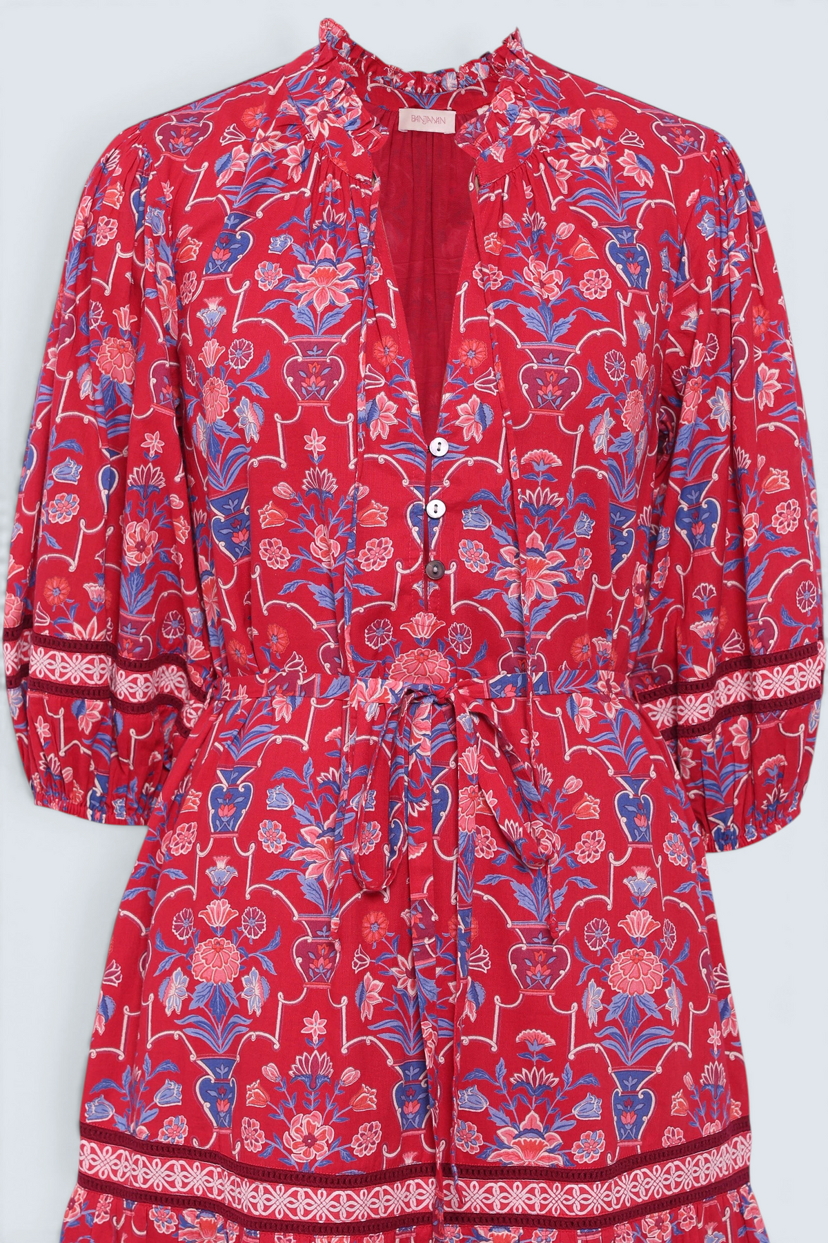 Front view close up of the Liza dress in Floral Vase print. It features a tie neckline, soft ruffles, lace sleeve and a fabric belt.