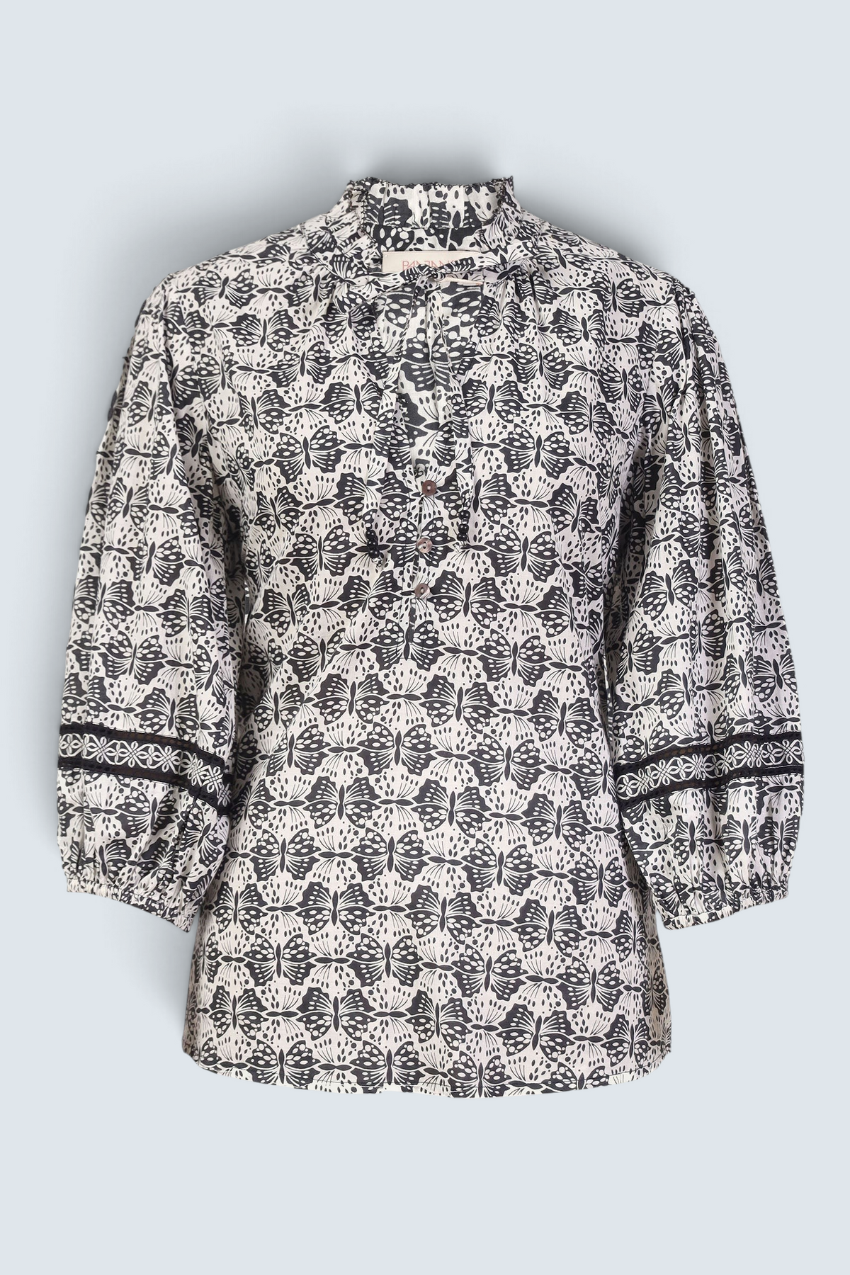 Banjanan Lorna top in black and white cotton voile with butterfly print, v-neck, ruffle trim, and lace sleeve detail.