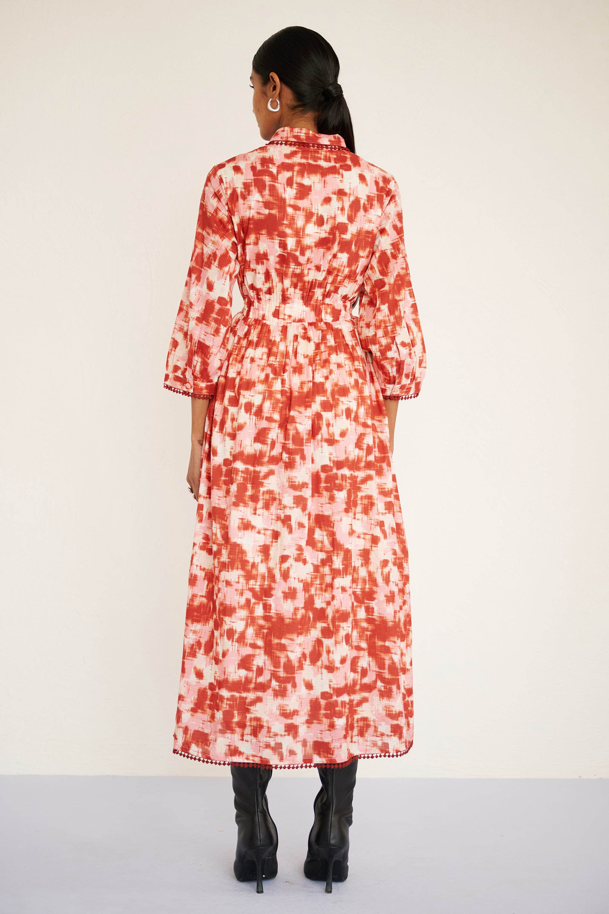 Back view of woman wearing a tailored cotton midi shirtdress with lace trim at the collar, placket, and hem, featuring an ikat-inspired animal print.