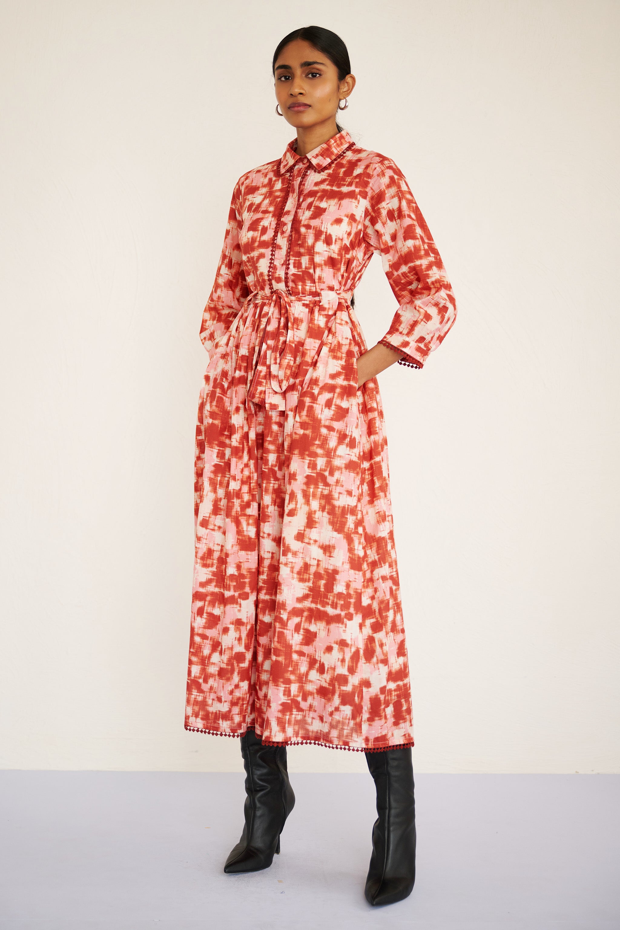 Front side view of woman wearing a tailored cotton midi shirtdress with lace trim at the collar, placket, and hem, featuring an ikat-inspired animal print.