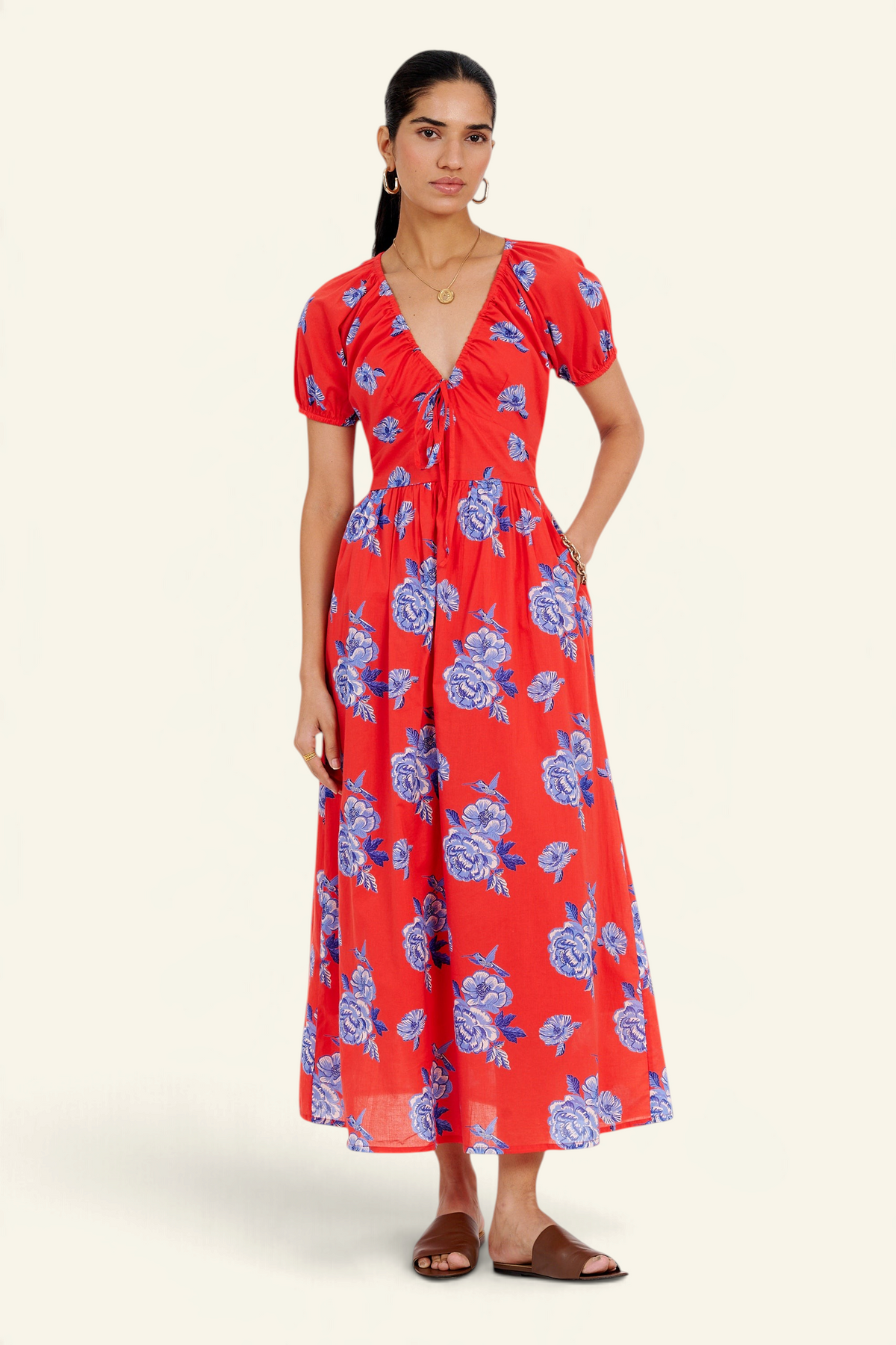 Banjanan Norma dress in poppy red with blue floral print, featuring a drawstring neckline and puff sleeves.