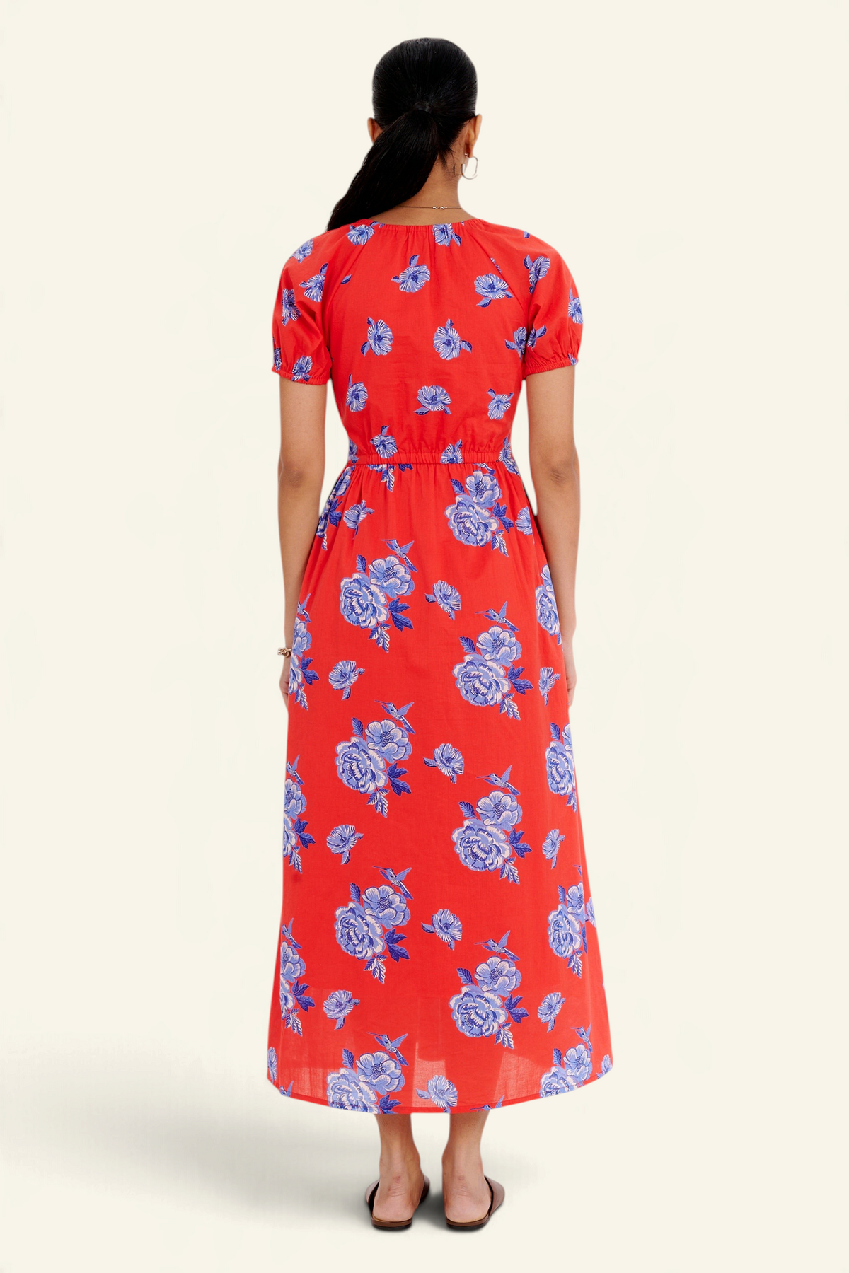 Banjanan Norma dress in poppy red with blue floral rose print, featuring a drawstring neckline and midi length.
