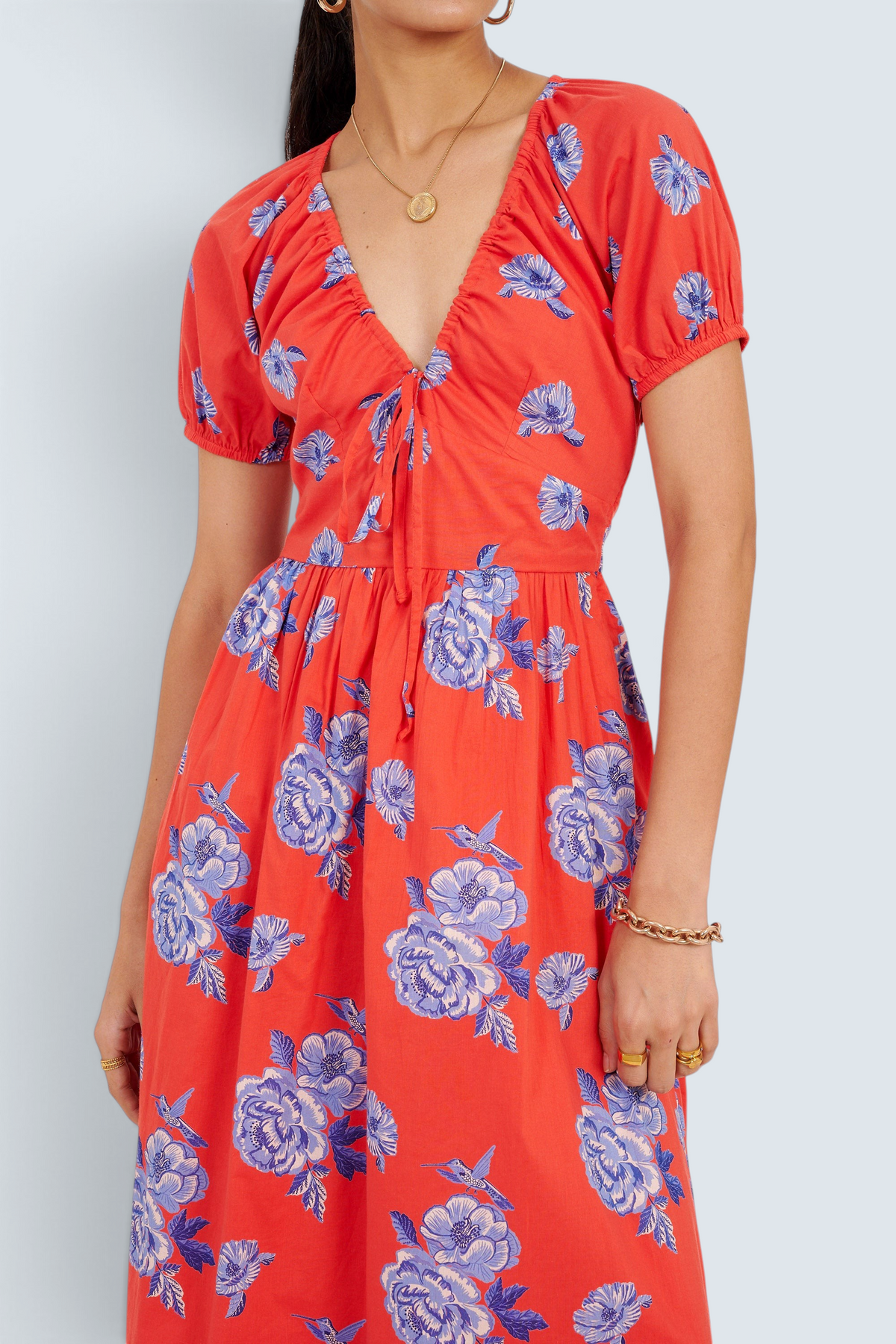 Banjanan Norma dress in poppy red with blue floral rose and hummingbird print, featuring a drawstring neckline.