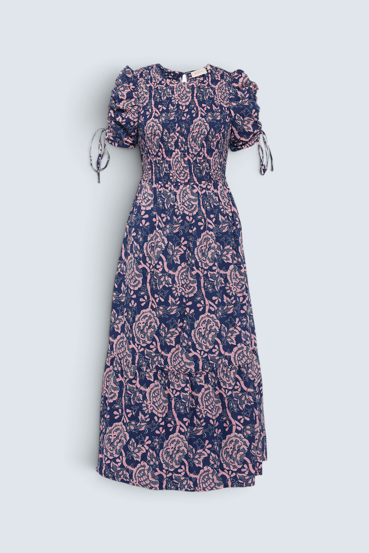 Front view of Banjanan Queenie midi dress in indigo and pink Coromandel floral print with smocked bodice and drawstring sleeves.