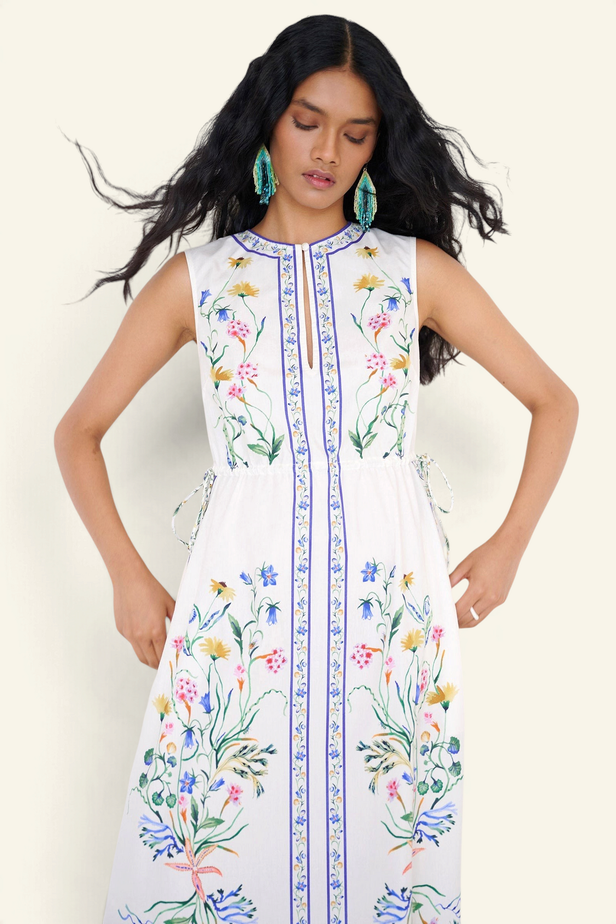 Front view close up of a woman standing wearing the Rhonda column dress in Tidepool print, featuring side drawstrings with gold caps, front keyhole button, and side-seam pockets.