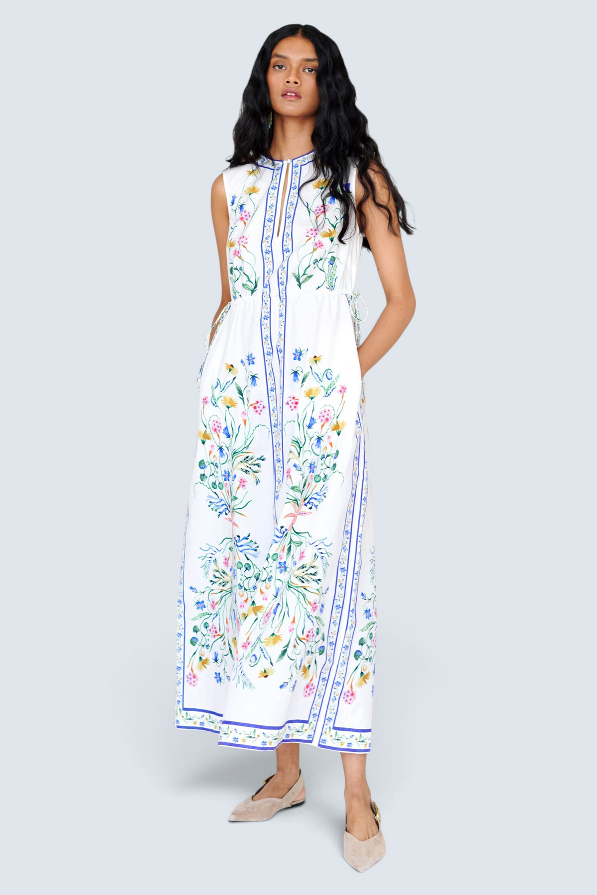 Front view of a woman standing wearing the Rhonda column dress in Tidepool print, featuring side drawstrings with gold caps, front keyhole button, and side-seam pockets.