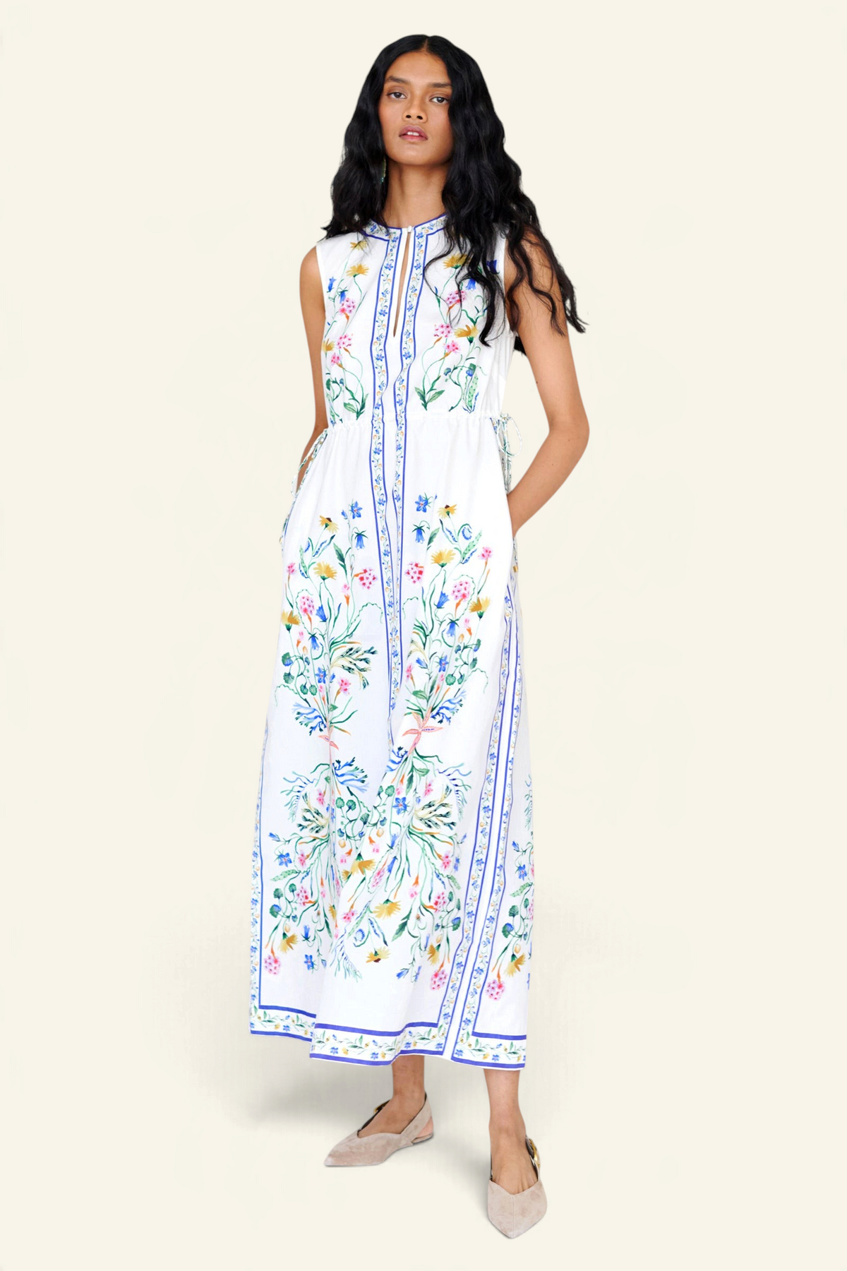 Front view of a woman standing wearing the Rhonda column dress in Tidepool print, featuring side drawstrings with gold caps, front keyhole button, and side-seam pockets.