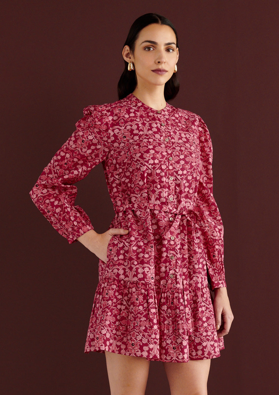 Front view close up of woman standing with her right hand in pocket. She is wearing the Roma mini dress in Ottoman print, with wrist-length sleeves, smooth cotton cambric, detachable belt, side-seam pockets, and fully lined construction in rich Berry red color.