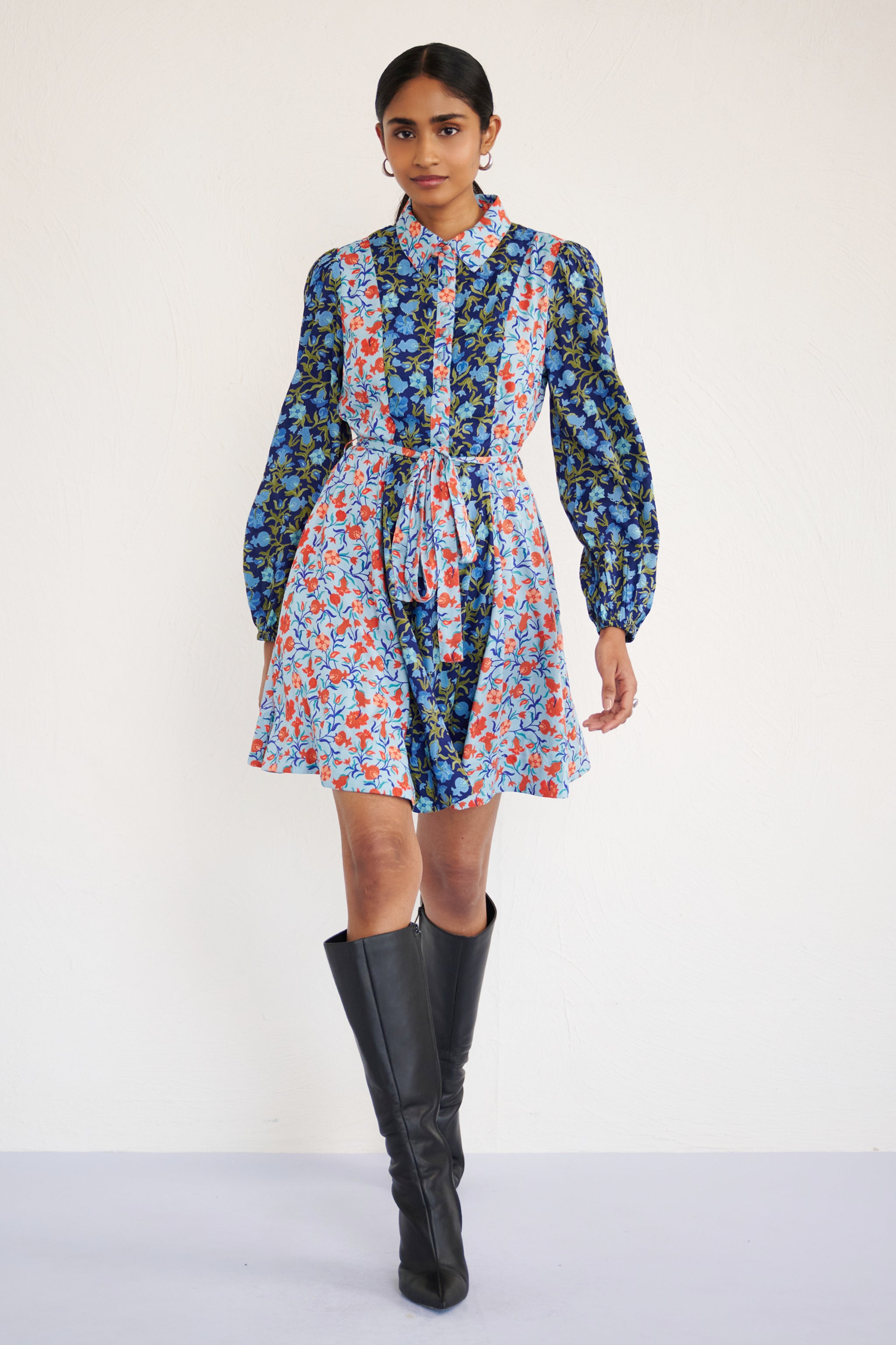 Front view of woman wearing a mini shirtdress with lantern sleeves, a delicate collar, and contrast pomegranate vine print, styled with side pockets.