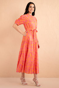 Side view of model wearing a full length Saylor Dress in Gaia Nectarine print. Side view of model wearing a full length Saylor Dress in Gaia Nectarine print.