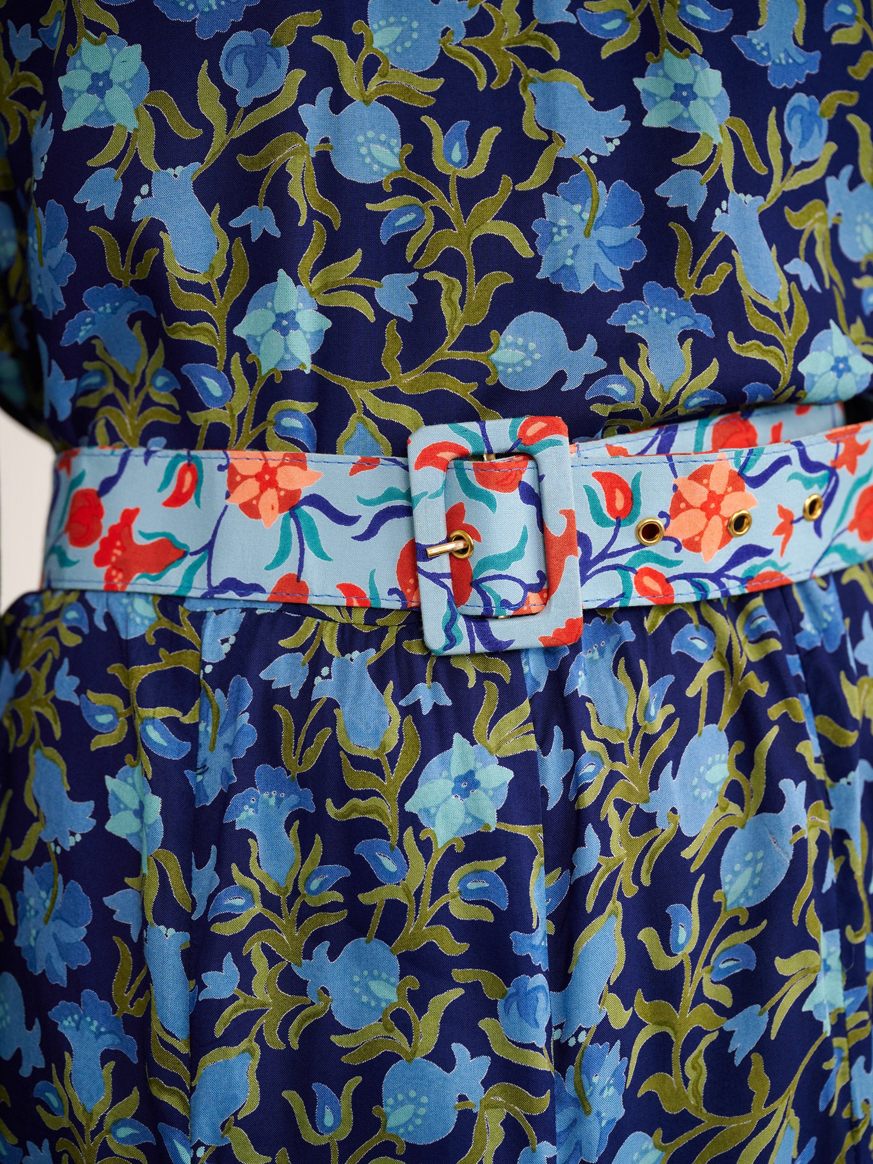Close up of buckle belt detail in contrast color of Sumina Dress in Pomegranate Vine Lapis print.