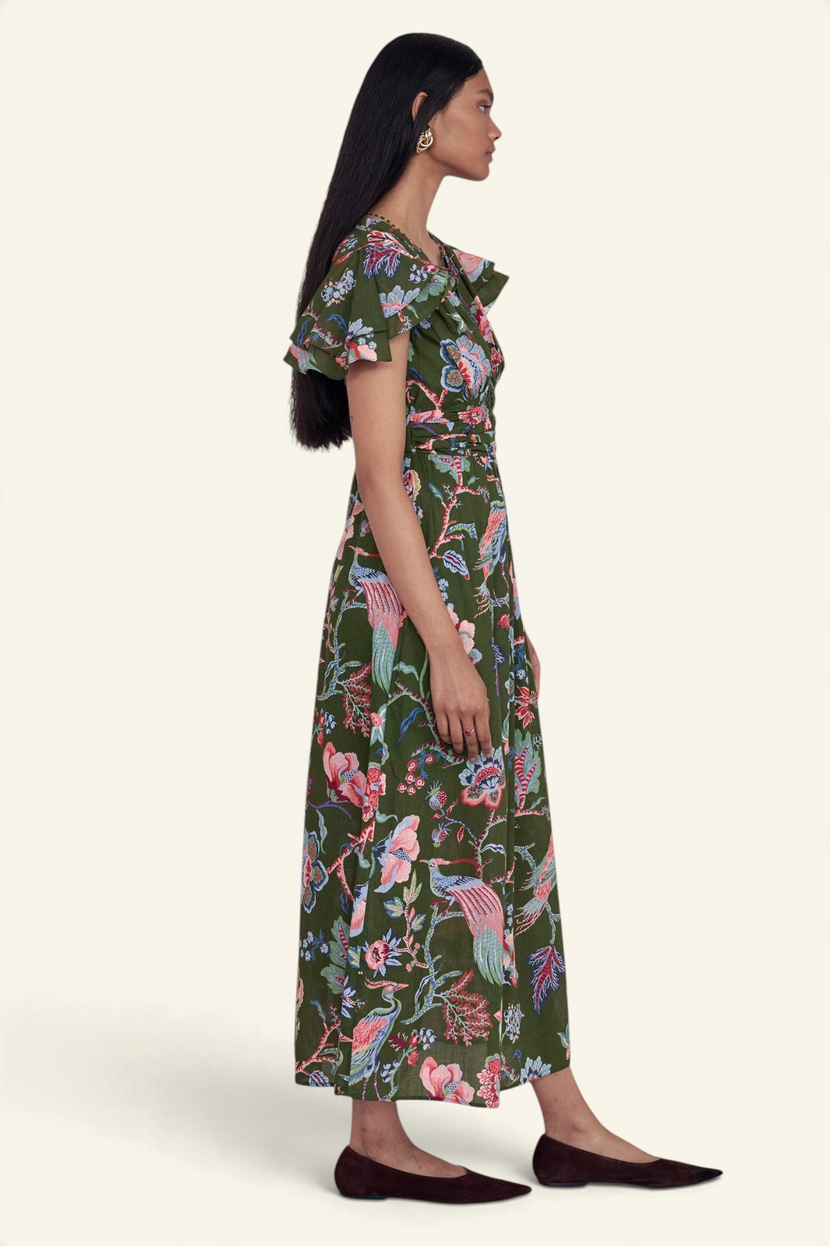 Model wearing Banjanan Adele dress in moss green chintz floral print with flutter sleeves and v-neck side profile