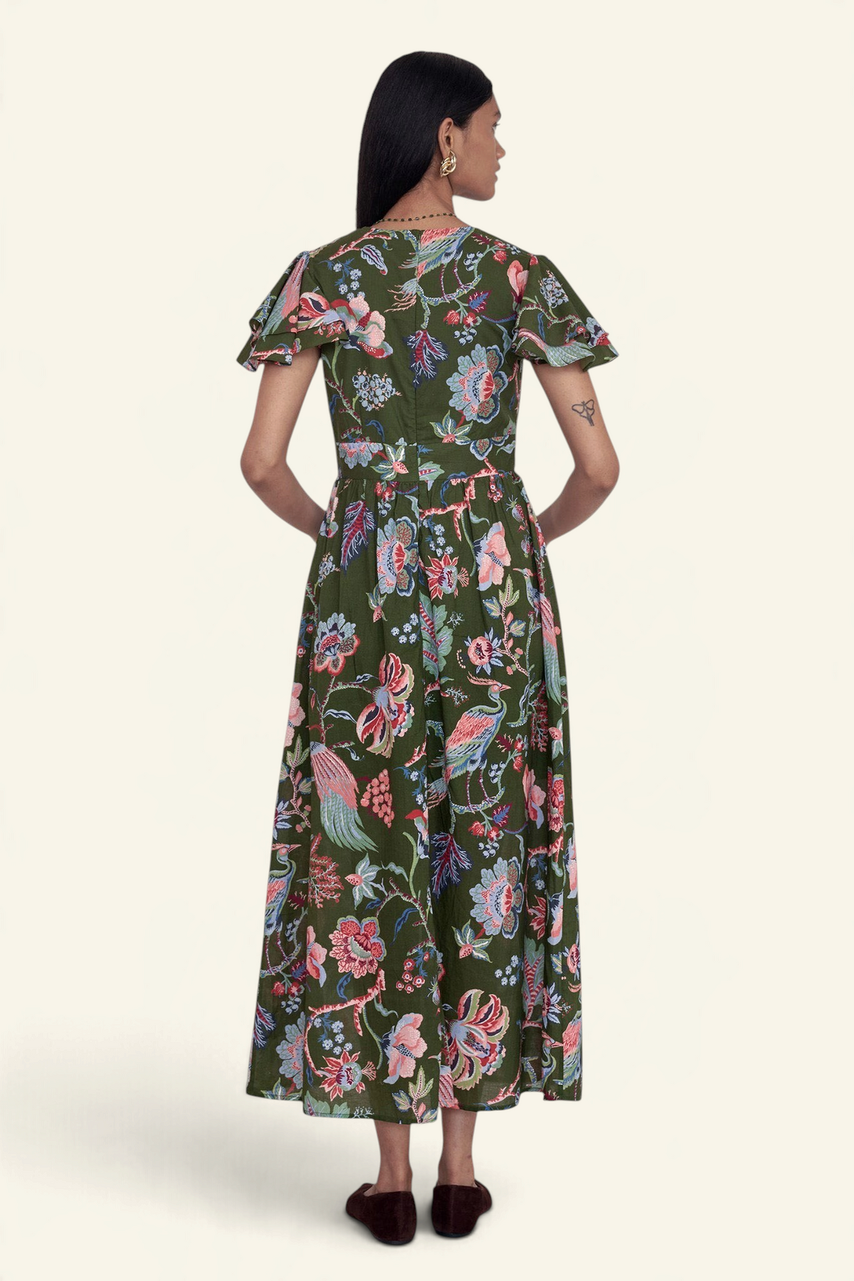 Back view of a Banjanan Adele dress in moss green with a floral chintz print, flutter sleeves, and midi length.