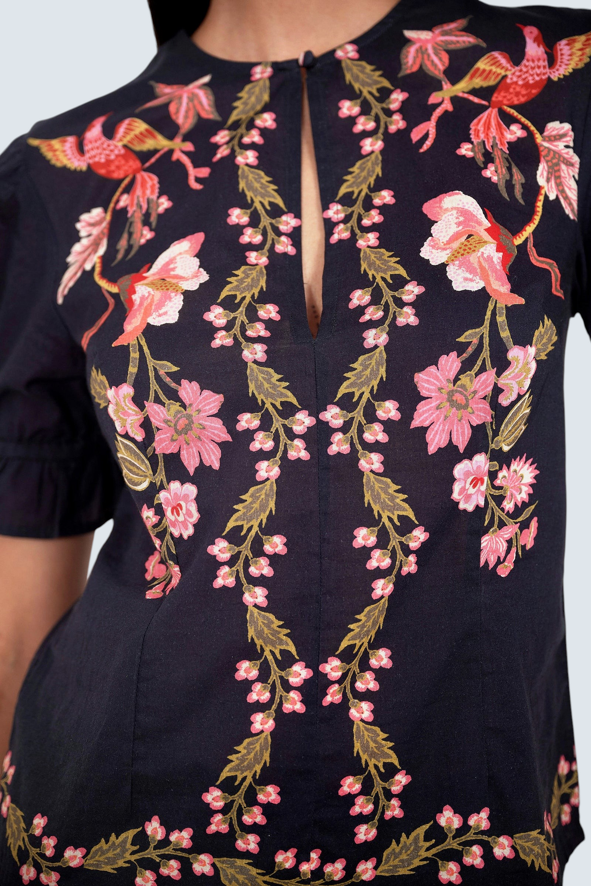 Front view close up of model standing. She is wearing the Ricki top in Chintz print, featuring a crewneck with keyhole detail, adjustable drawstring sleeves, and vintage-inspired print placement.