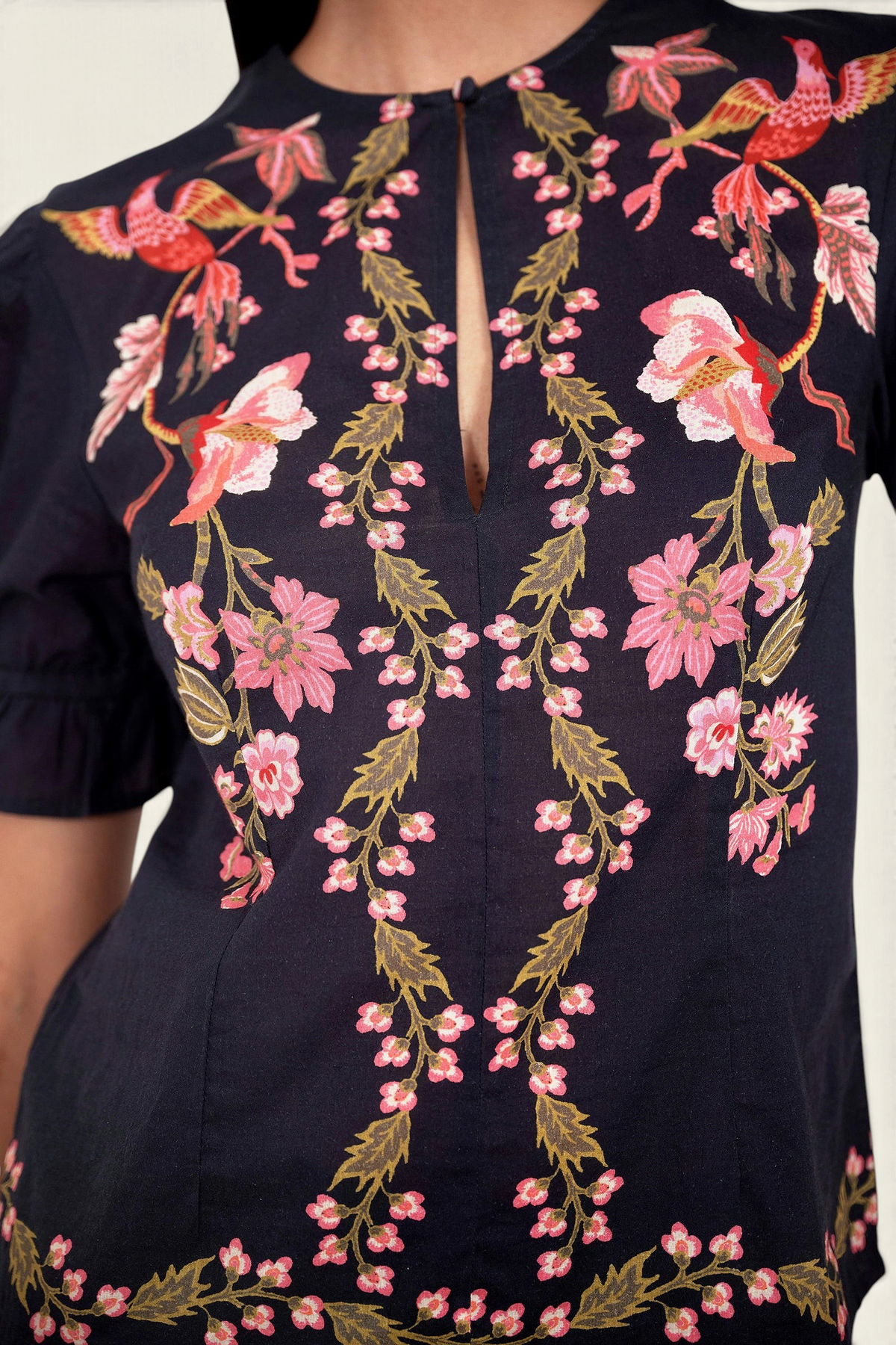 Front view close up of model standing. She is wearing the Ricki top in Chintz print, featuring a crewneck with keyhole detail, adjustable drawstring sleeves, and vintage-inspired print placement.