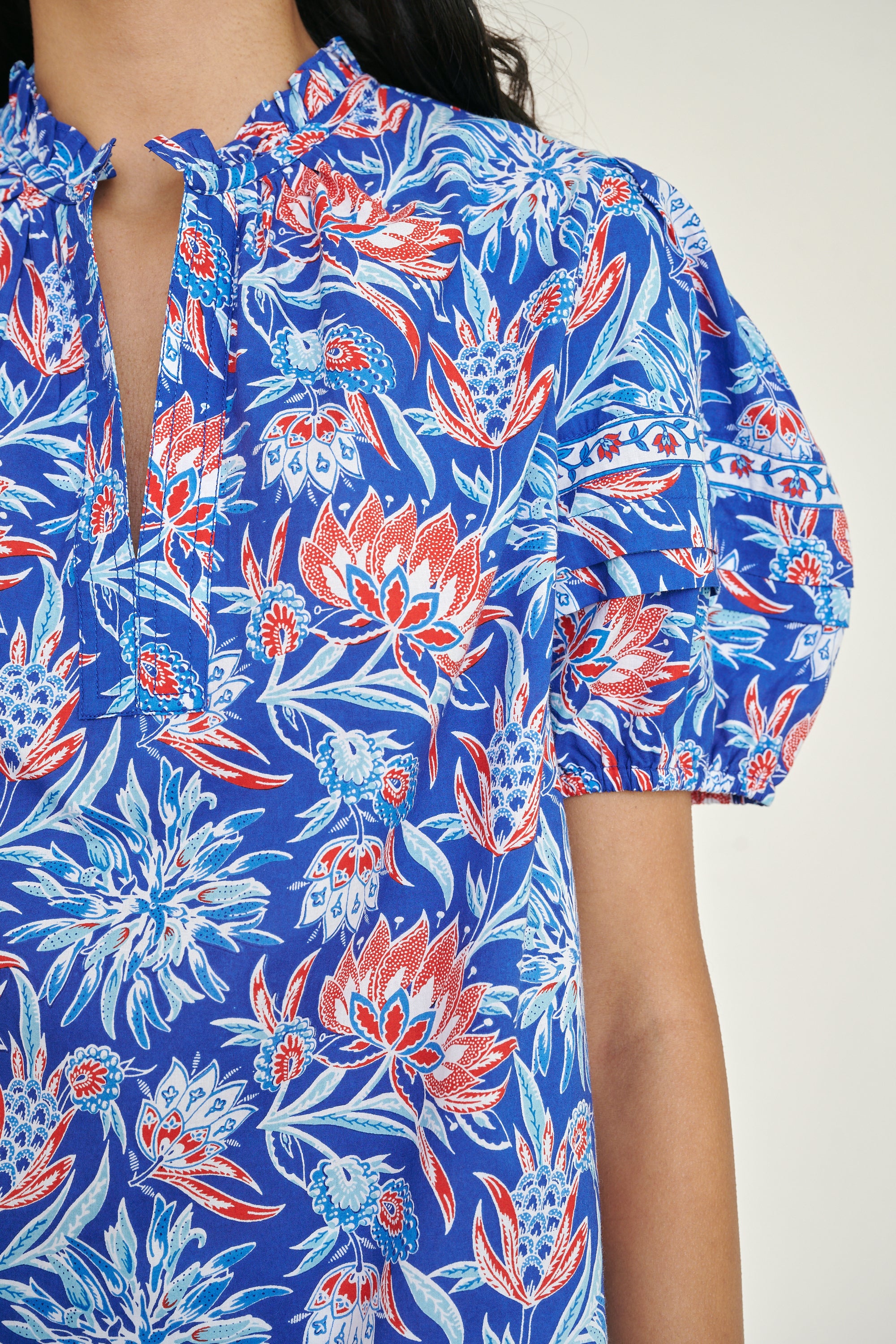 Front view close up the Bronte top in the Philippa print, featuring a front opening, delicate contrast trim, pleated sleeves, and a hand-screen-printed wildflower pattern.