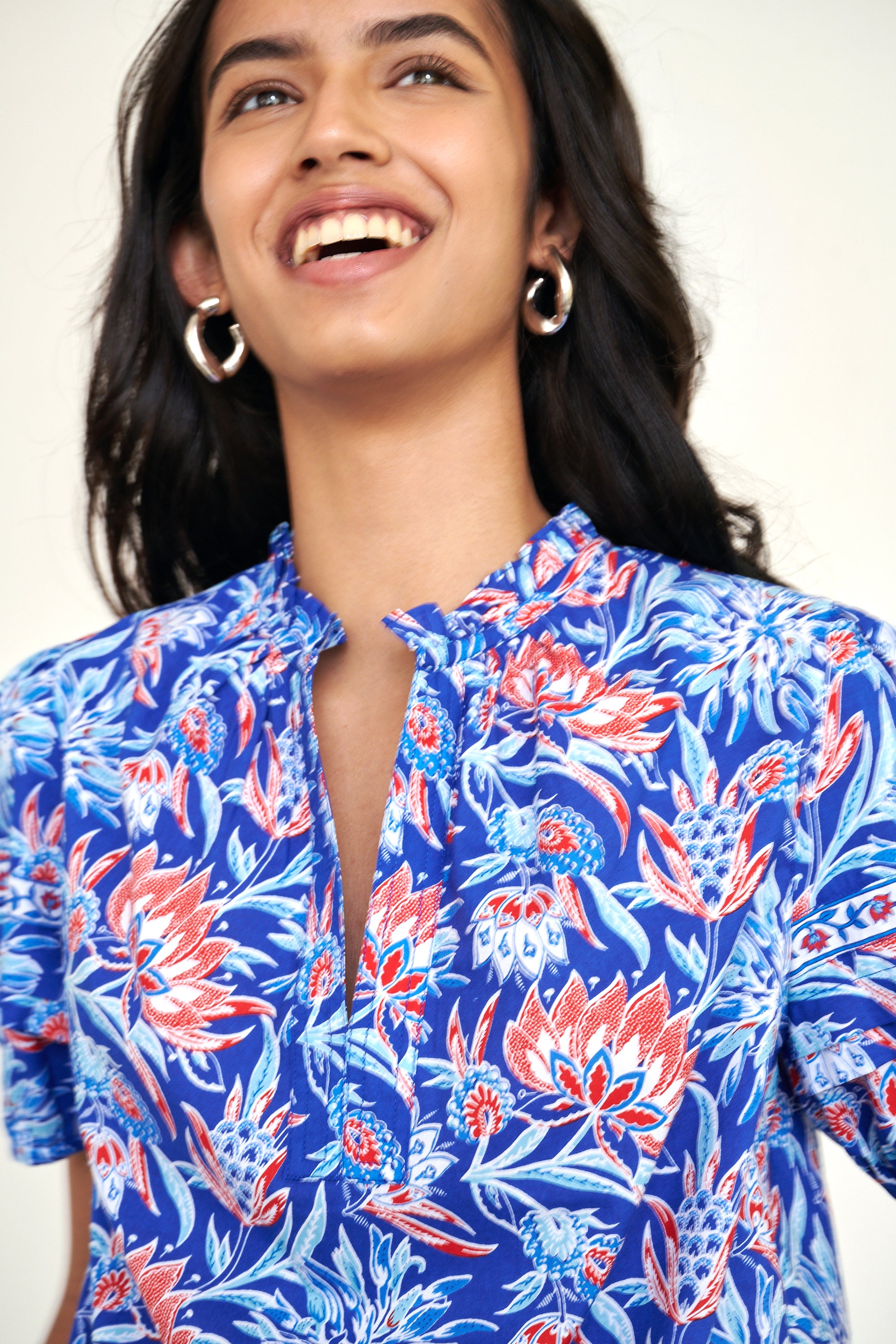 Close up of the Bronte top in the Philippa print, featuring a front opening, delicate contrast trim, pleated sleeves, and a hand-screen-printed wildflower pattern.