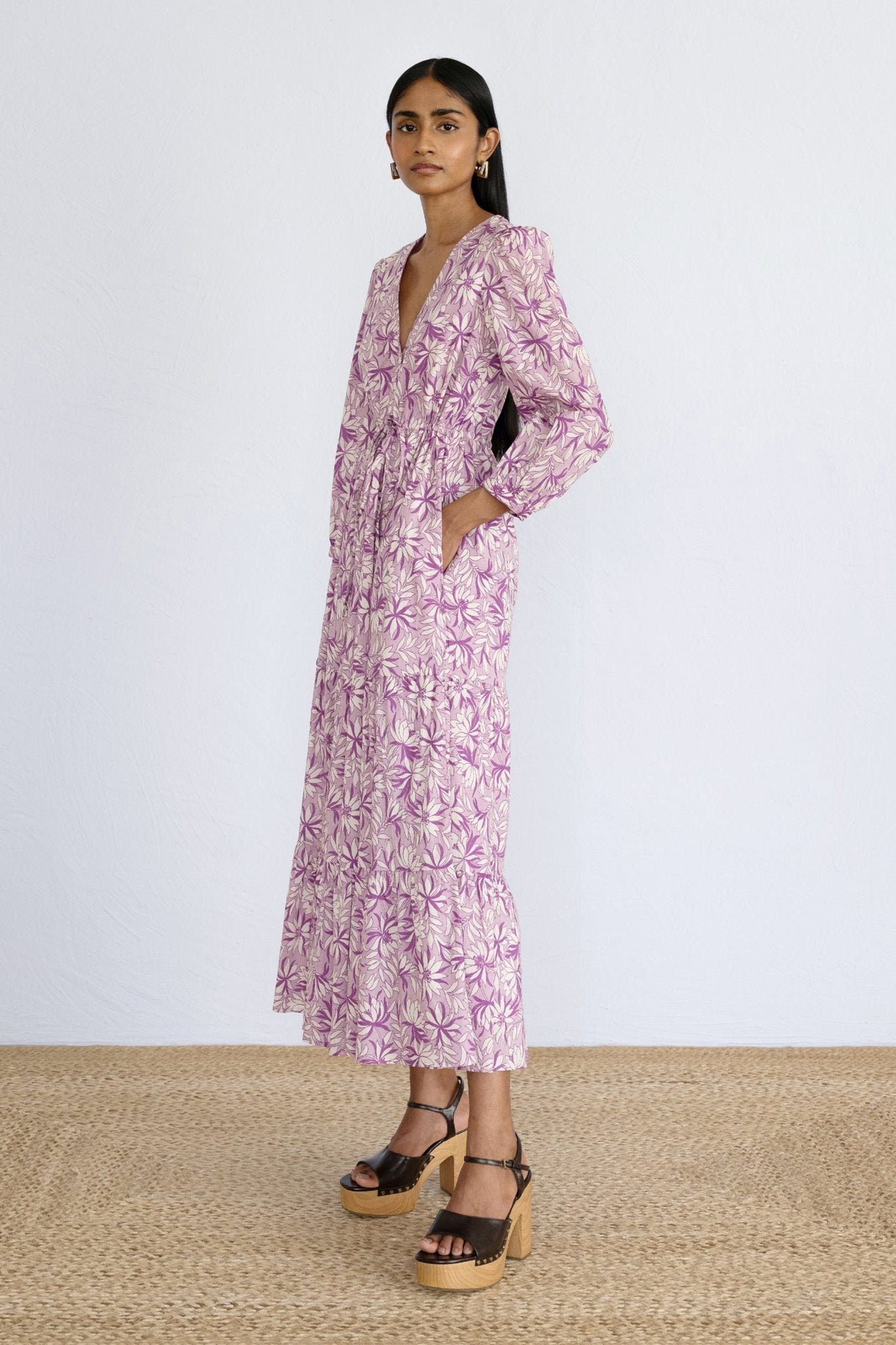 Front side view of model standing wearing a full length Castor Dress in Jacaranda Lilac print.