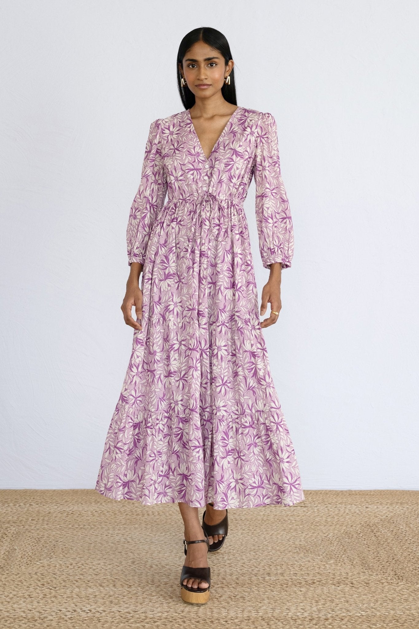 Front view of model stepping forward wearing a full length Castor Dress in Jacaranda Lilac print.