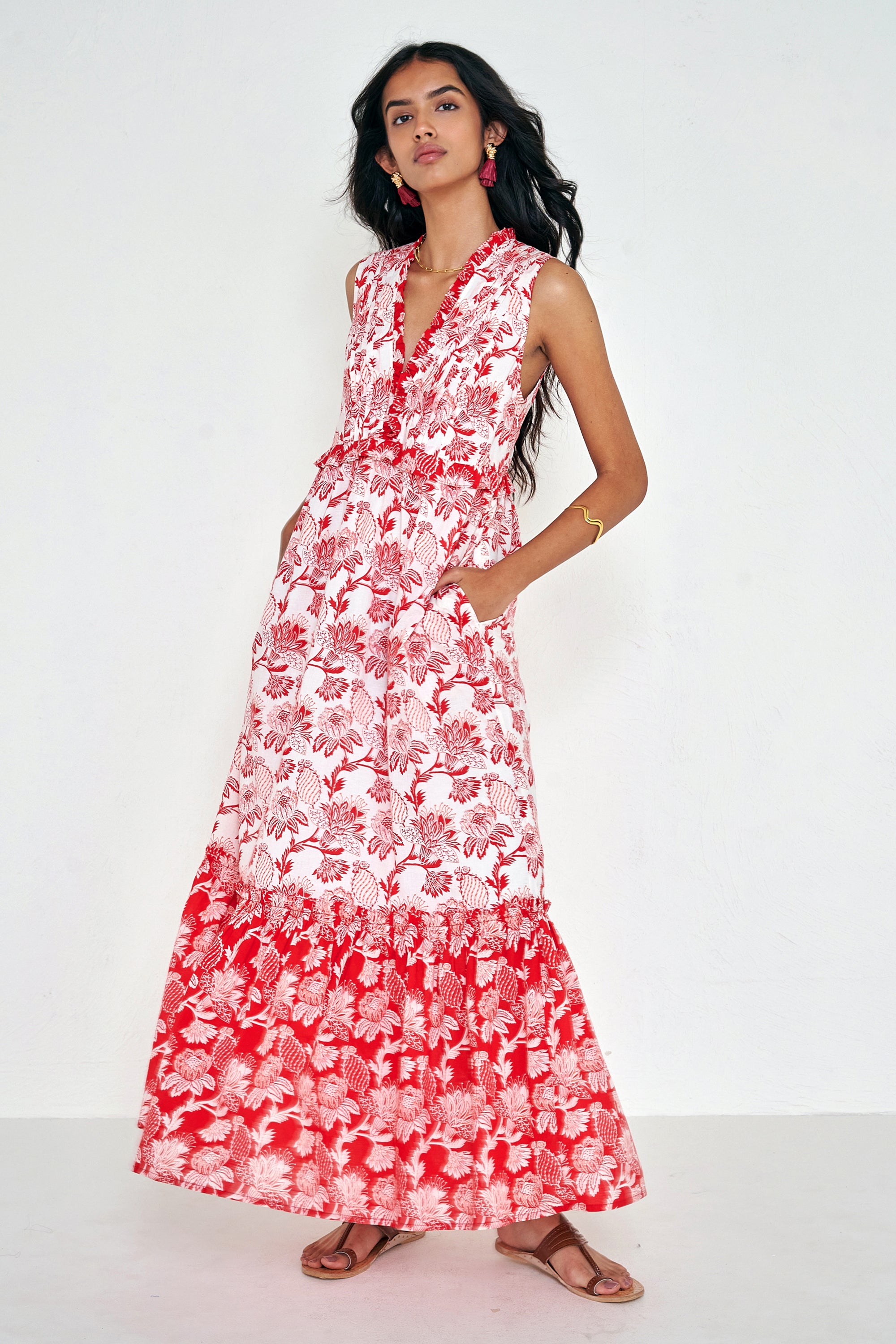 Front view of woman standing. She is wearing the Constance dress in the Lizzie print, featuring an A-line silhouette, pleated neckline, soft frill details, and floral vine motifs inspired by Provence.