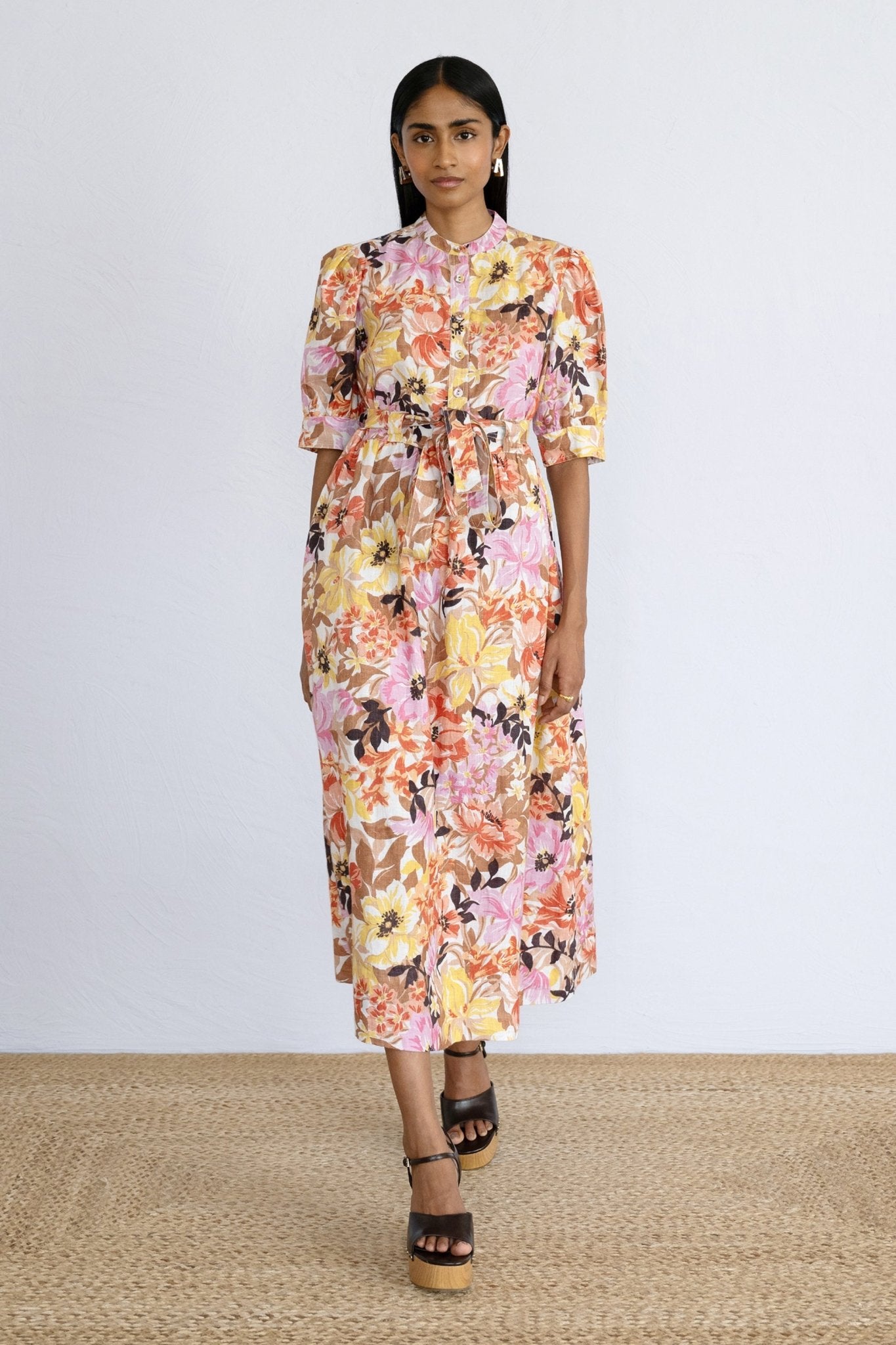 Front view of model stepping forward wearing a calf length Daffodil Dress Bouquet Antique.