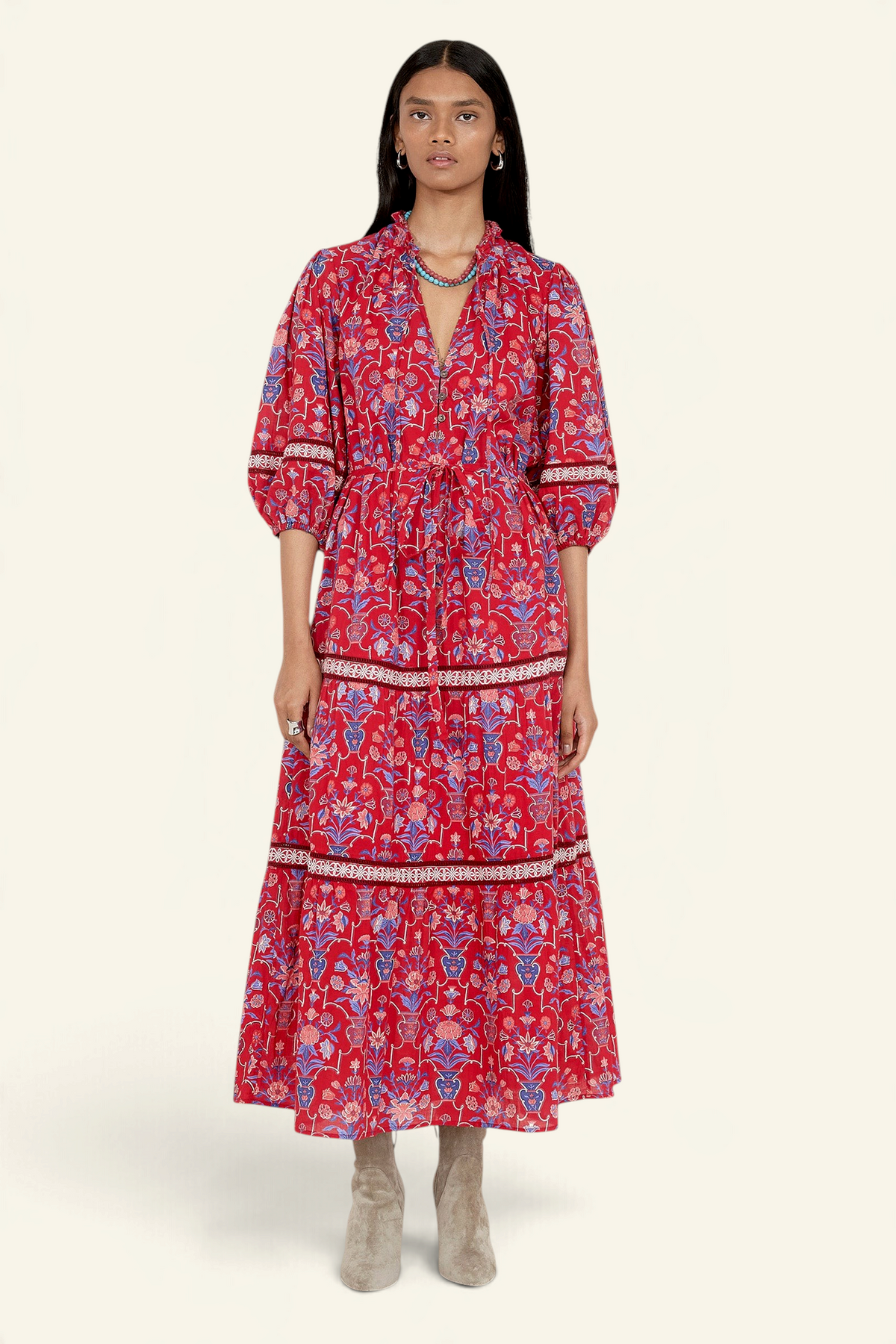 Banjanan Liza dress in cinnabar red with geometric floral print, lace trim, puff sleeves, and fabric waist belt.