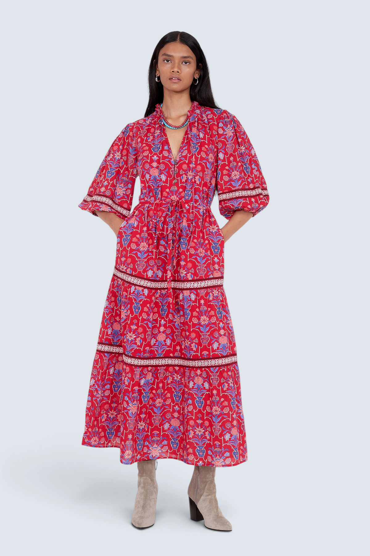 Front view of model standing. She is wearing the Liza dress in Floral Vase print. It features a tie neckline, soft ruffles, lace sleeve and skirt details, and a fabric belt.