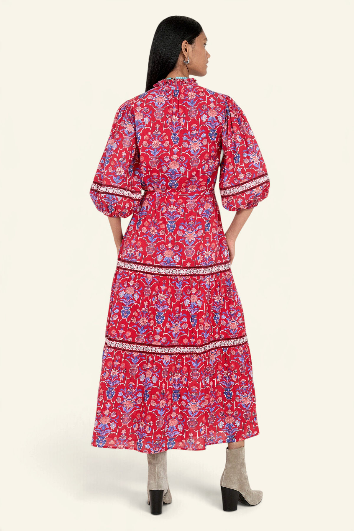 Banjanan Liza dress in cinnabar red with floral print, lace trim, puff sleeves, and a belted waist, back view.