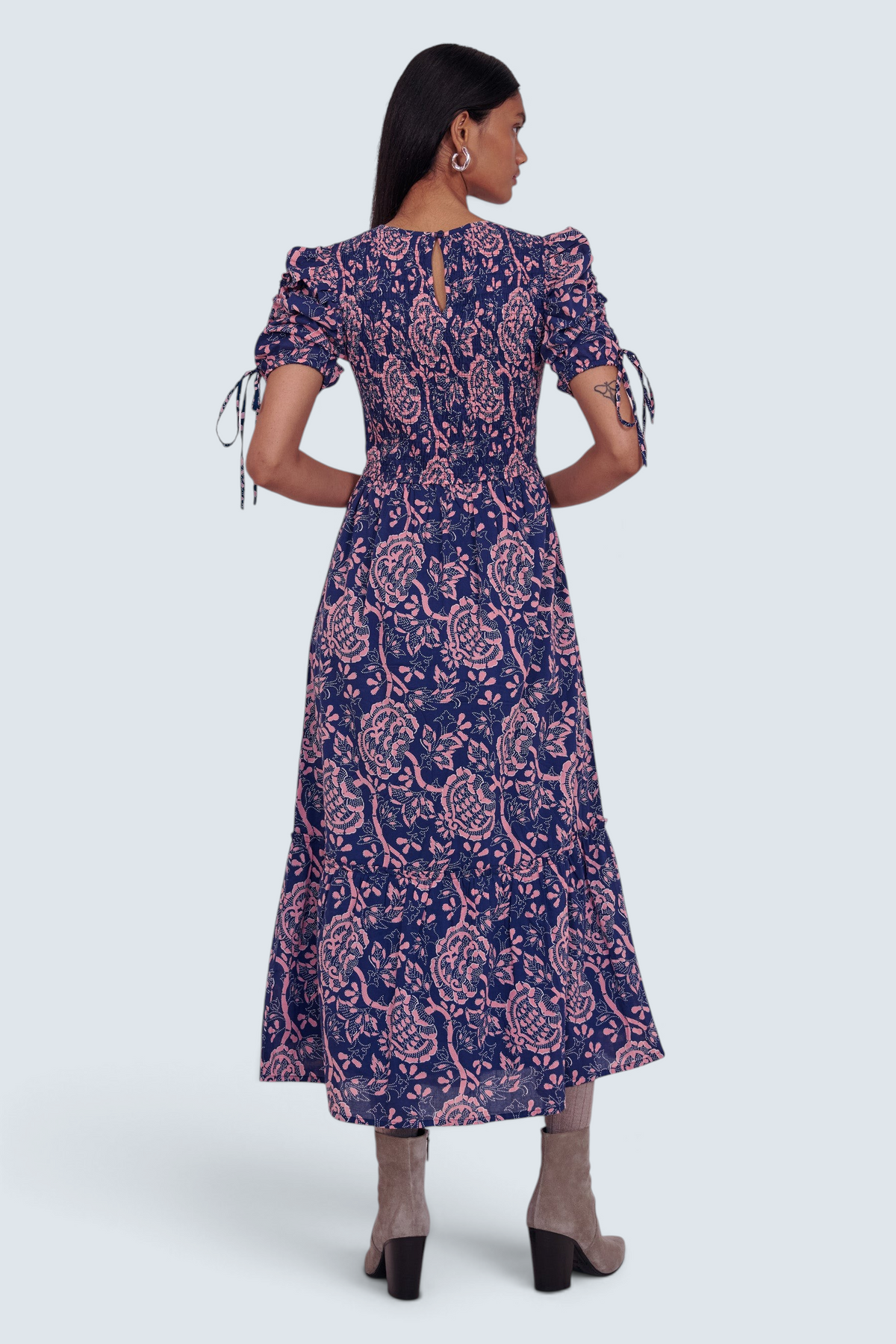 Banjanan Queenie midi dress in indigo and pink floral print with smocked bodice and drawstring sleeves, back view.