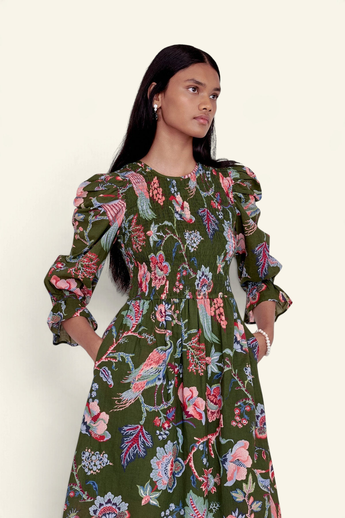 Banjanan Queenie dress in moss green with floral chintz print, smocked bodice, and elbow-length puff sleeves.