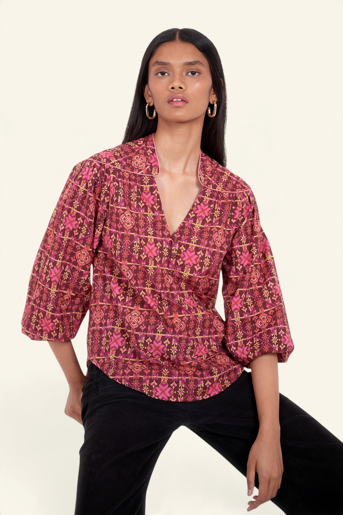 Front view of model. She is wearing Banjanan Vanessa top in mahogany cotton voile with a pink geometric floral needlepoint print and v-neckline.