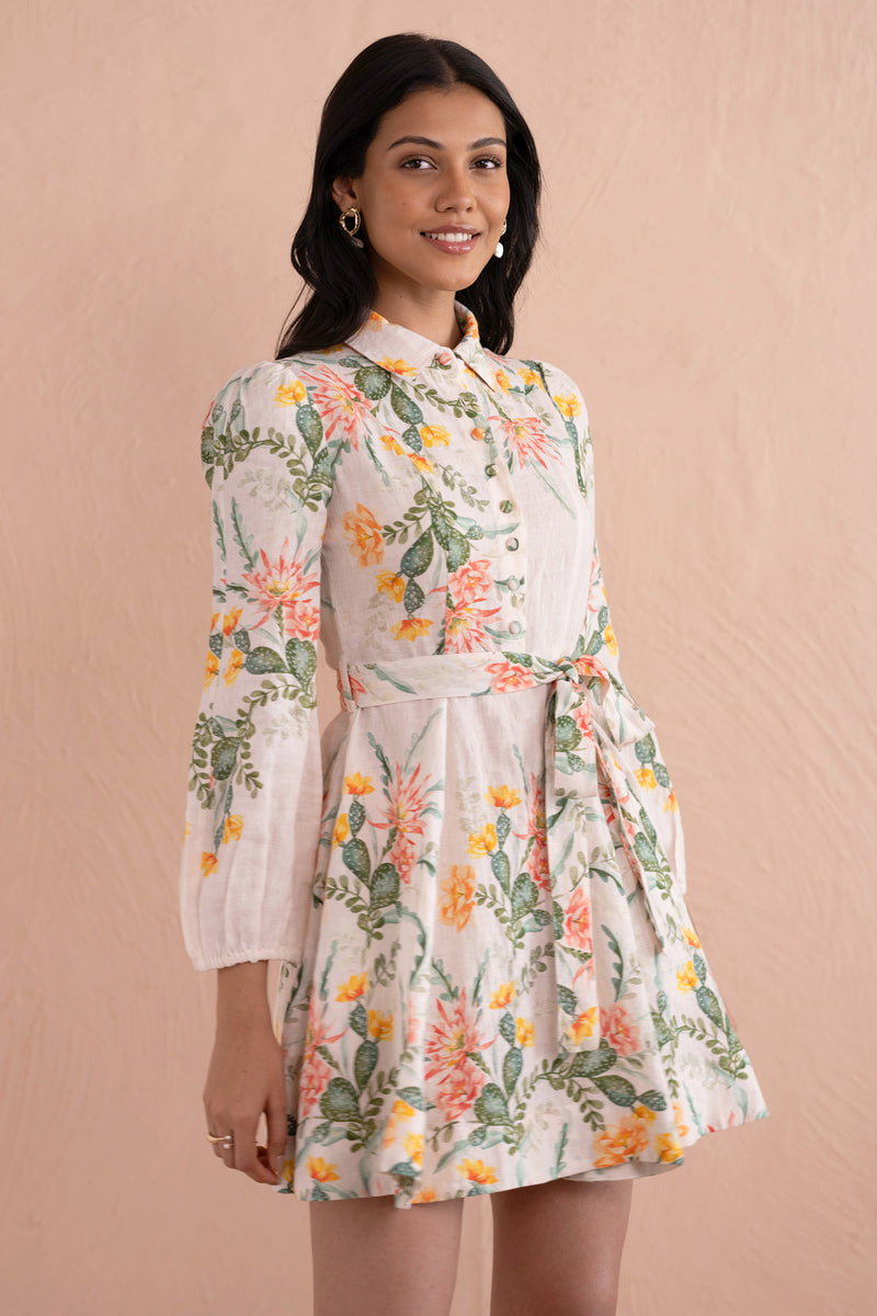 Front view close up of woman wearing Rowena Dress in Desert Rose Dawn print, a mini linen shirtdress with delicate collar, fabric-covered buttons, elegant lantern sleeves, and side-seam pockets featuring watercolor-style cactus flowers.