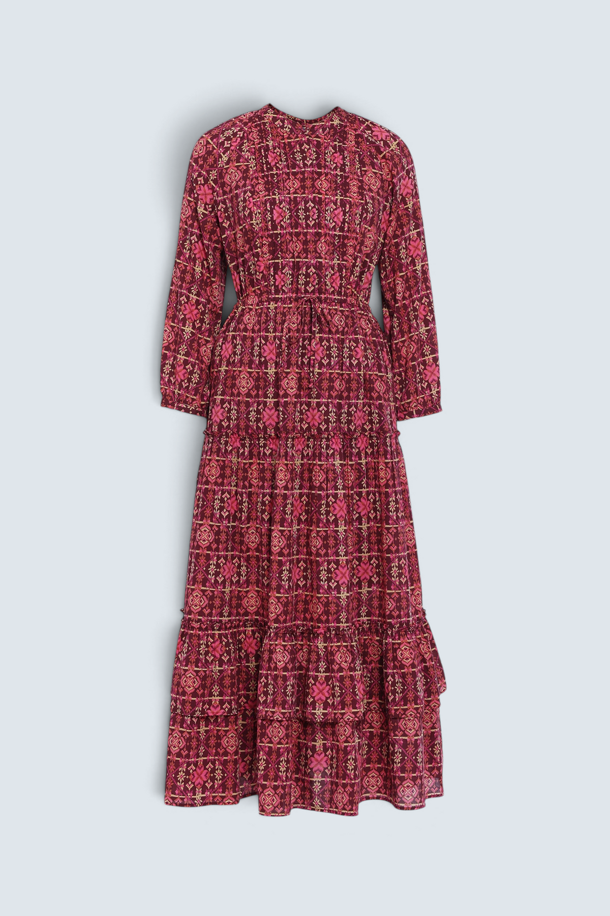 Banjanan Bazaar dress in mahogany cotton voile with a geometric needlepoint floral print, long sleeves, and tiers.