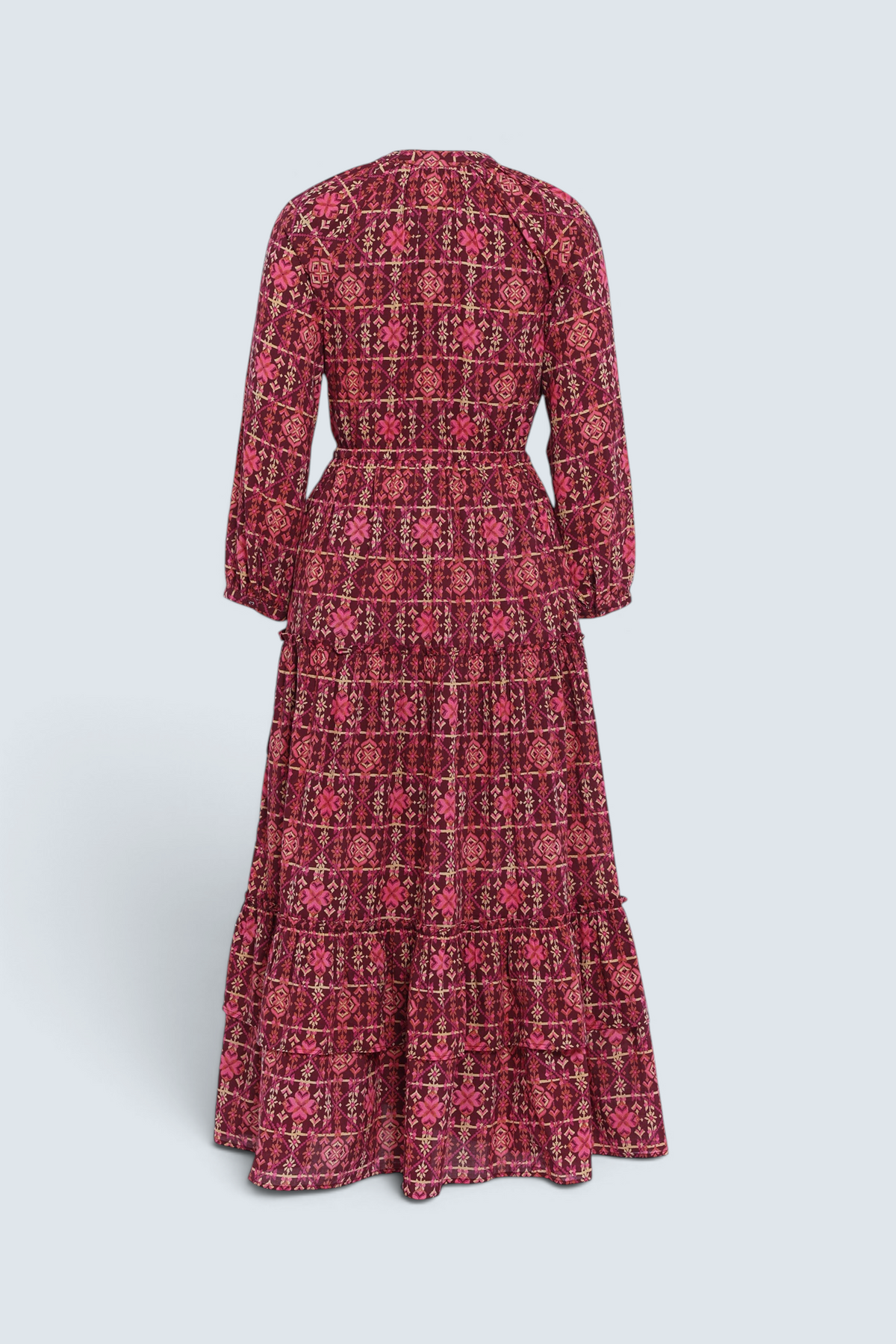 Banjanan Bazaar dress in mahogany cotton voile with a geometric needlepoint print, long sleeves, and tiered skirt.