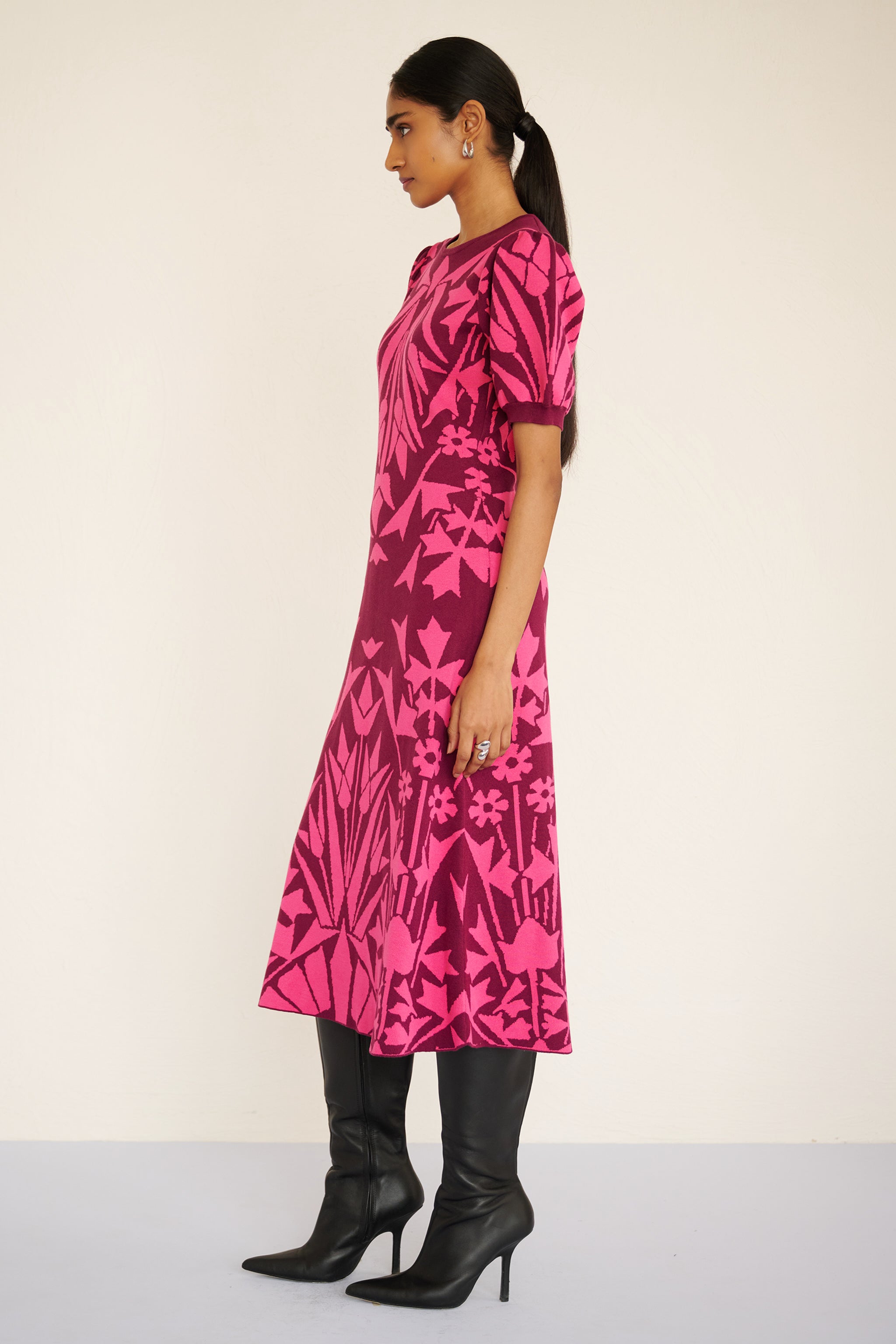 Side view of woman wearing a sleeveless jacquard midi dress with a fitted silhouette and hand-crocheted trim, featuring a textured, embroidery-inspired print.