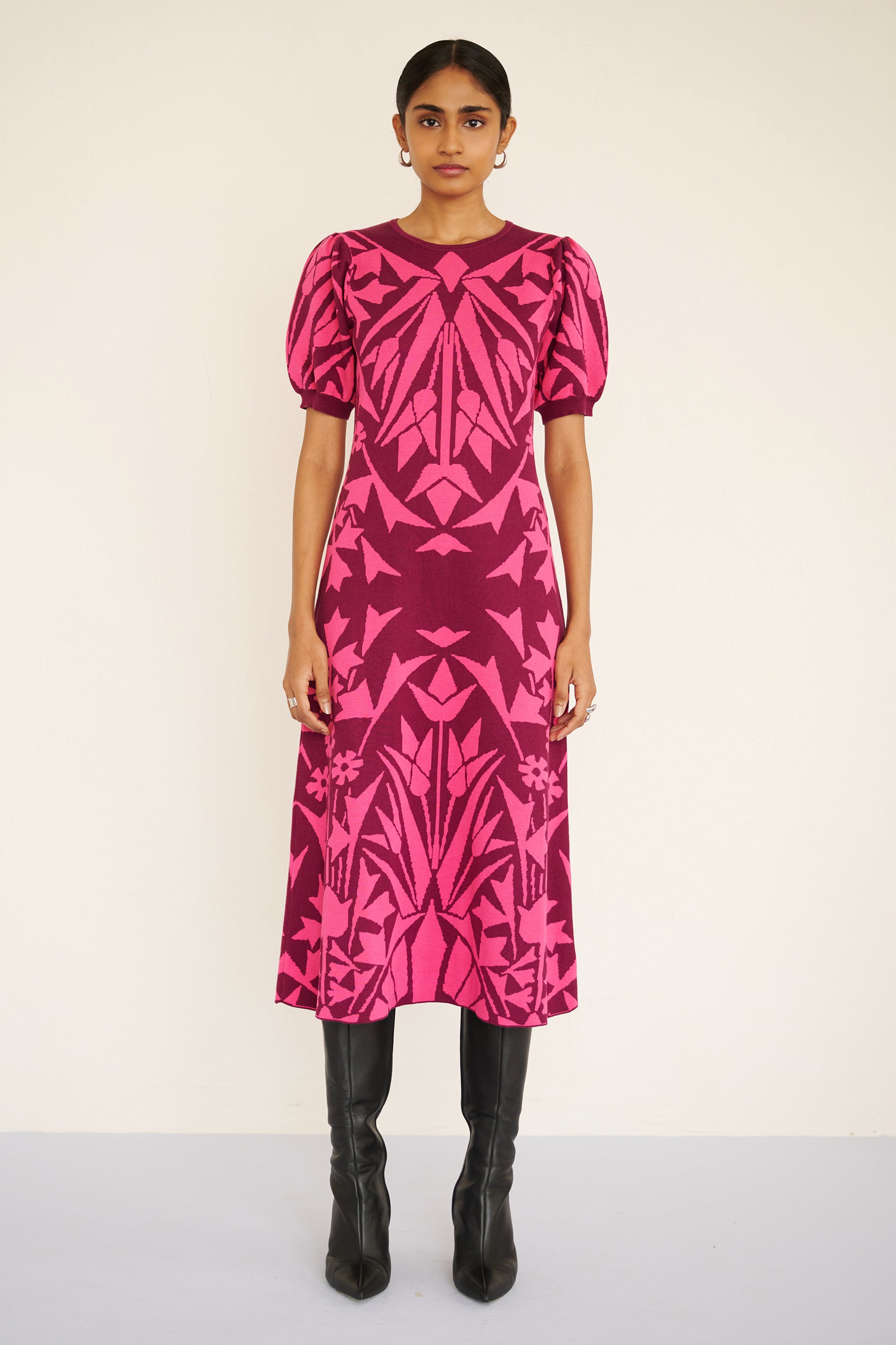 Front view of woman wearing a sleeveless jacquard midi dress with a fitted silhouette and hand-crocheted trim, featuring a textured, embroidery-inspired print.