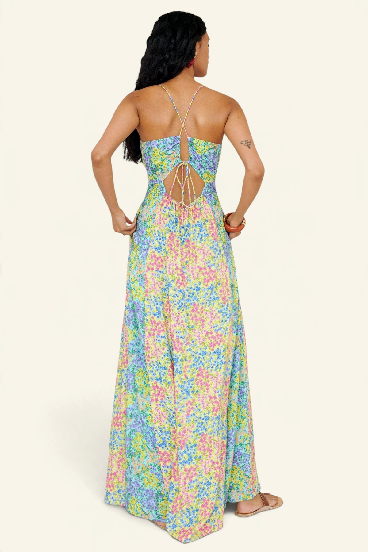 Banjanan Davina floral maxi dress with crossed tie-back straps and paneled skirt in pastel yellow, blue, and pink.