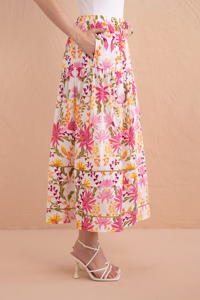 Side view close up of model wearing Gayle Skirt in Hydra Garland Rose with hands in her pocket.