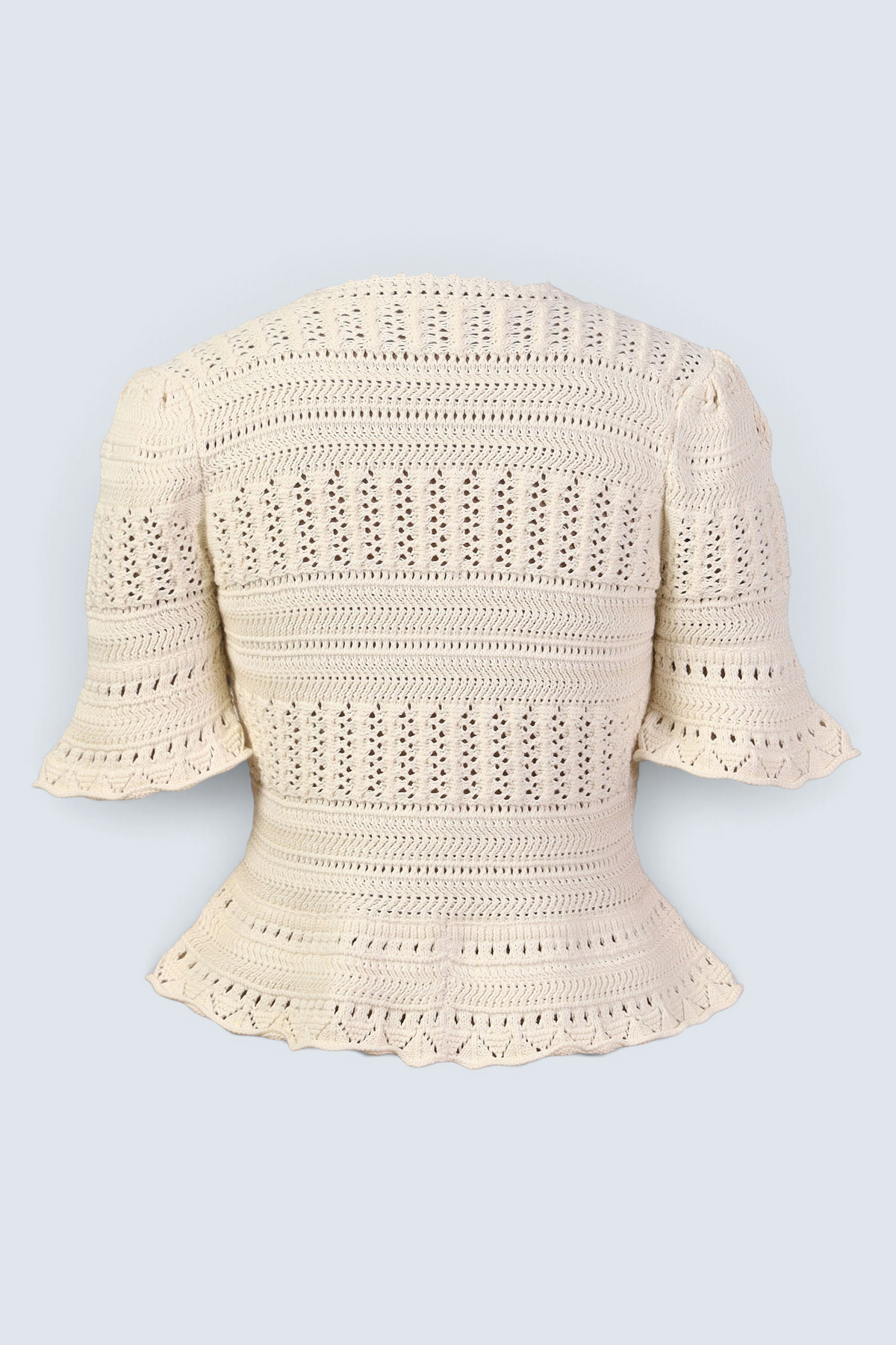 Banjanan ivory short sleeve cardigan featuring intricate hand-crocheted cotton patterns and a flared peplum hem.